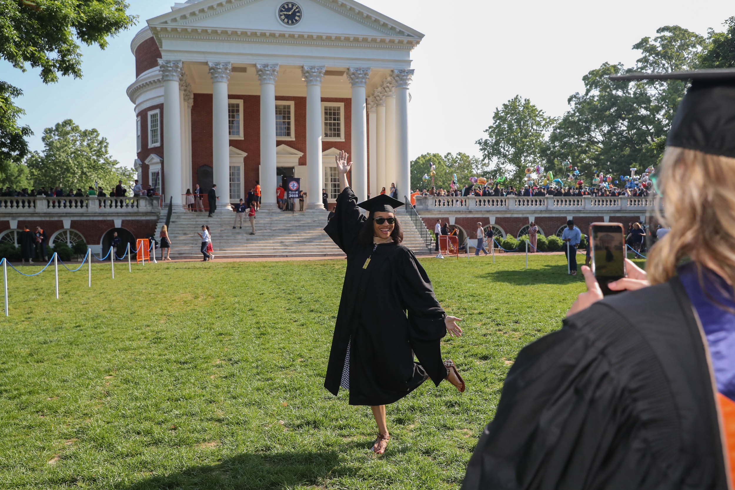 Graduate poses in front of the Rotunda for picture