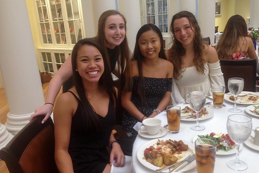 Students at a sit down dinner smiling