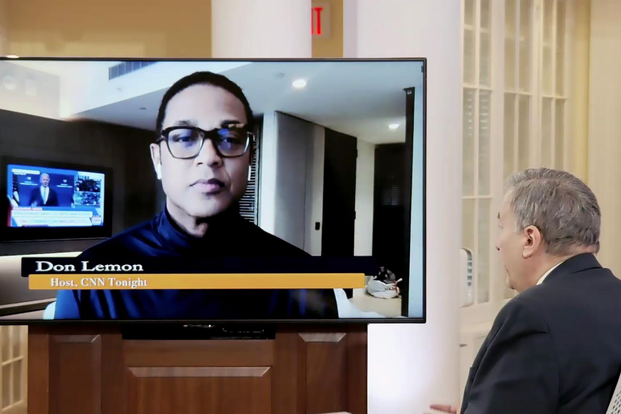 Don Lemon on tv screen speaking to Larry Sabato 