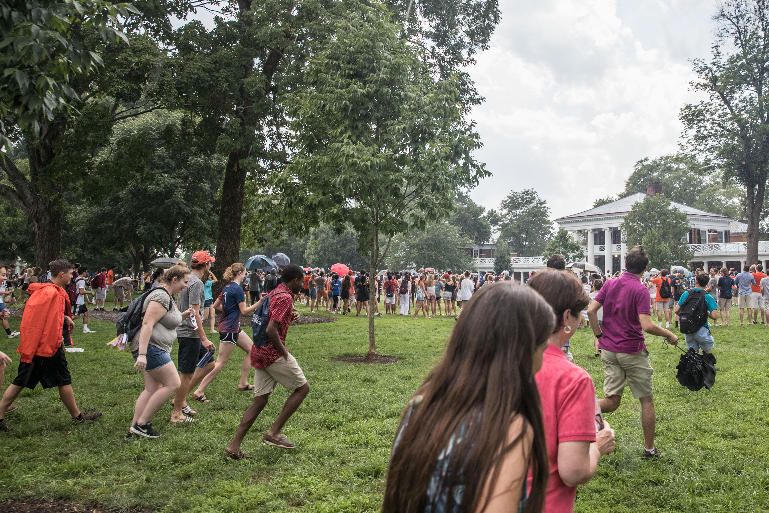 Students rush back onto the Lawn as the rain clears to view the peak of the eclipse.