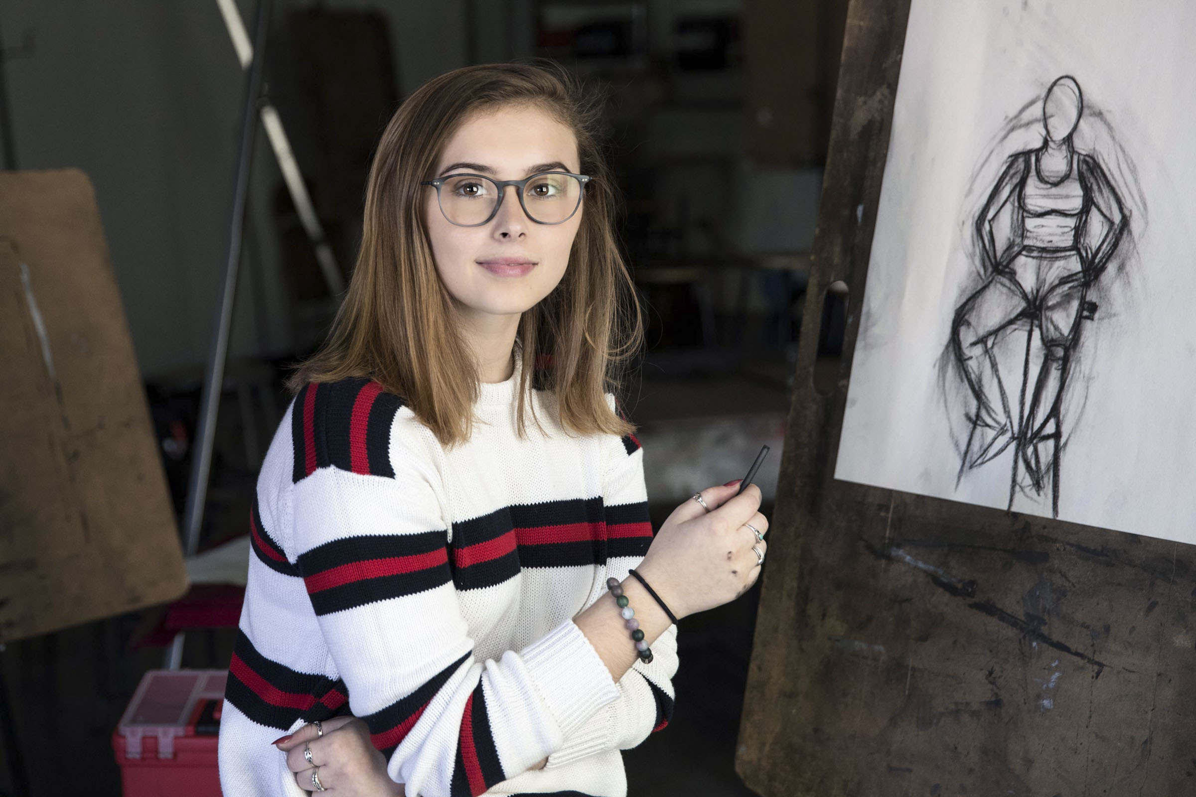 Emma Hitchcock stands next to a drawing she made