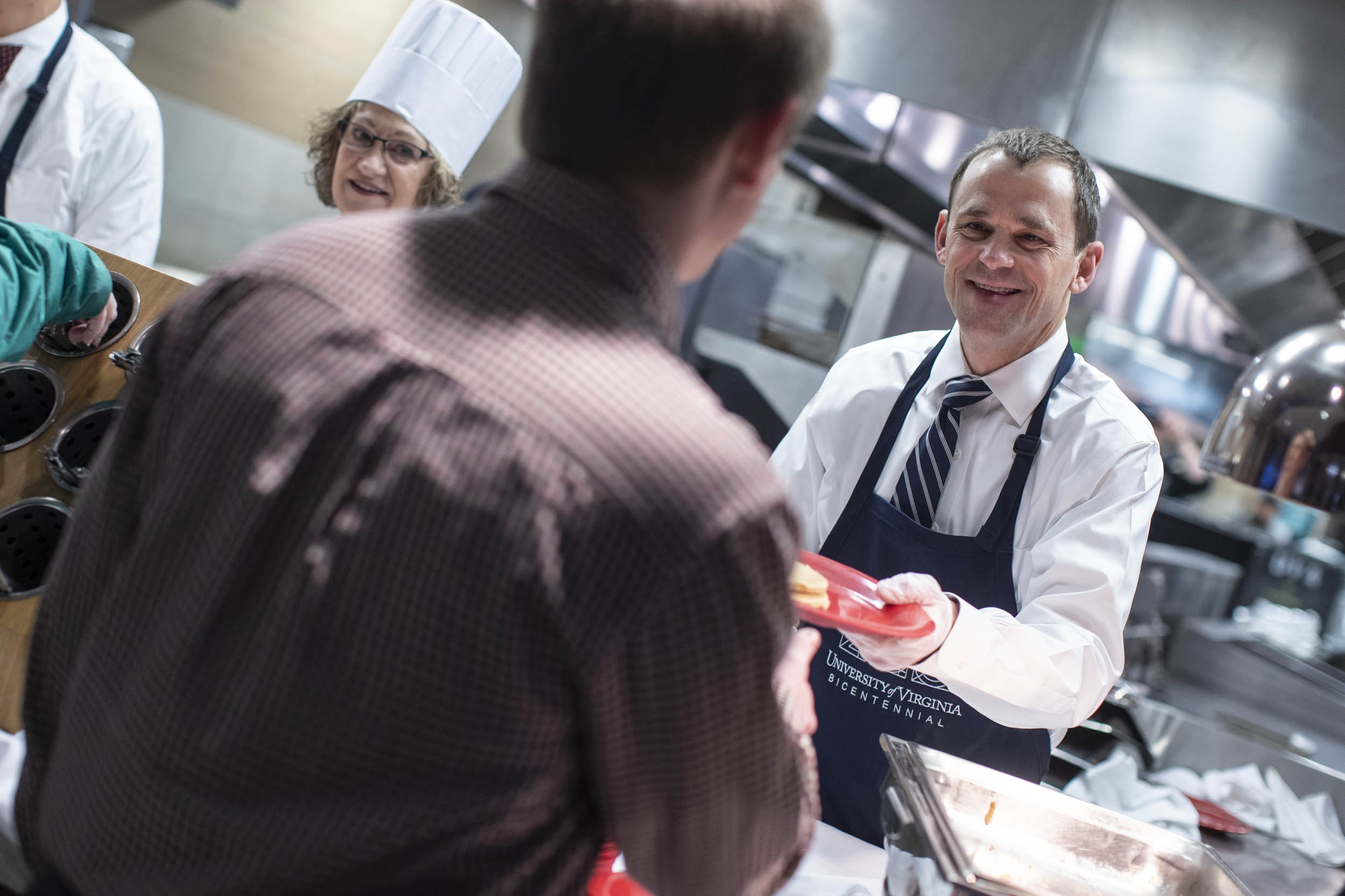 President Jim Ryan serving food to staff members