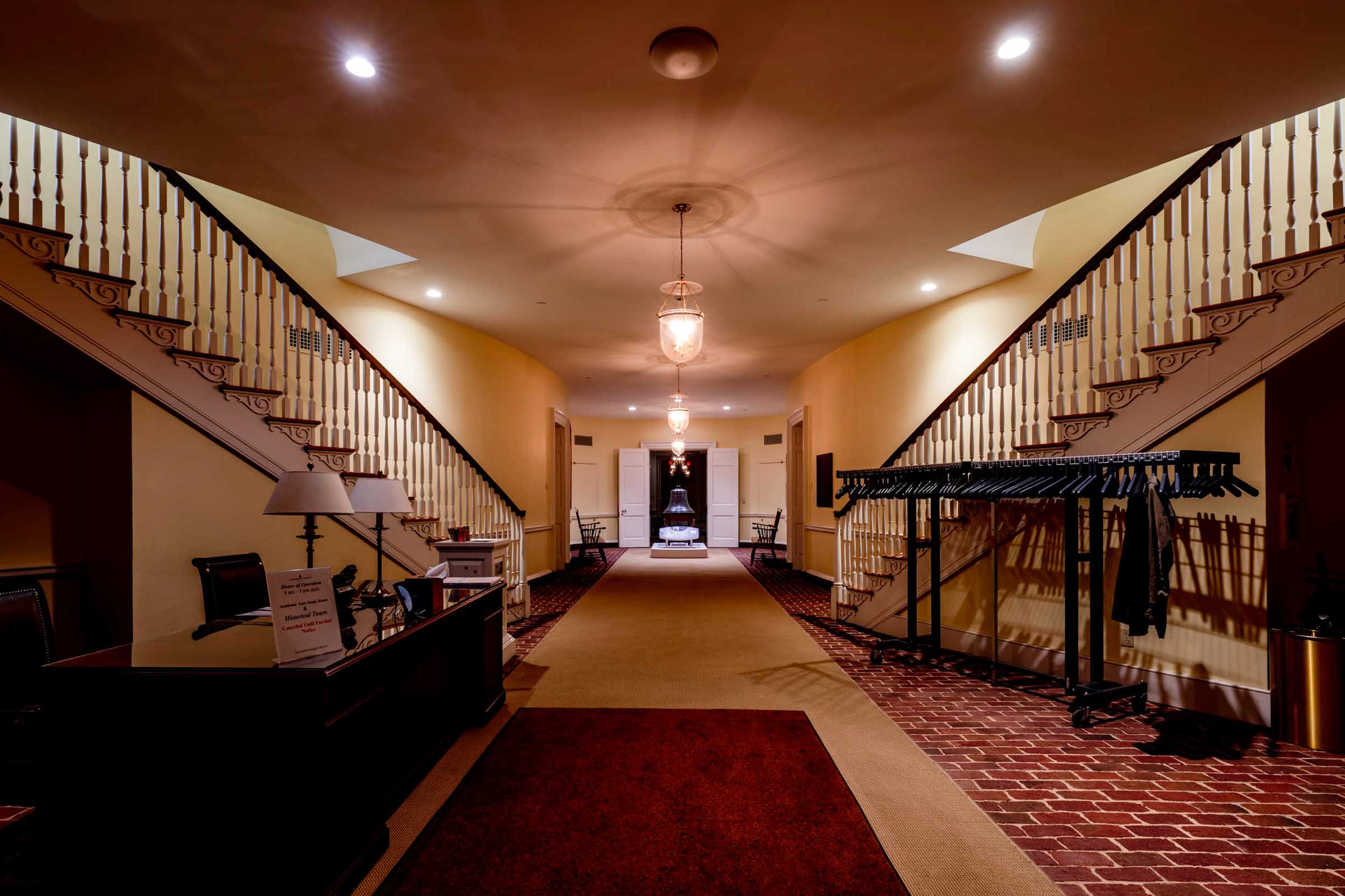 Empty carpeted hallway with two stair cases one on each side