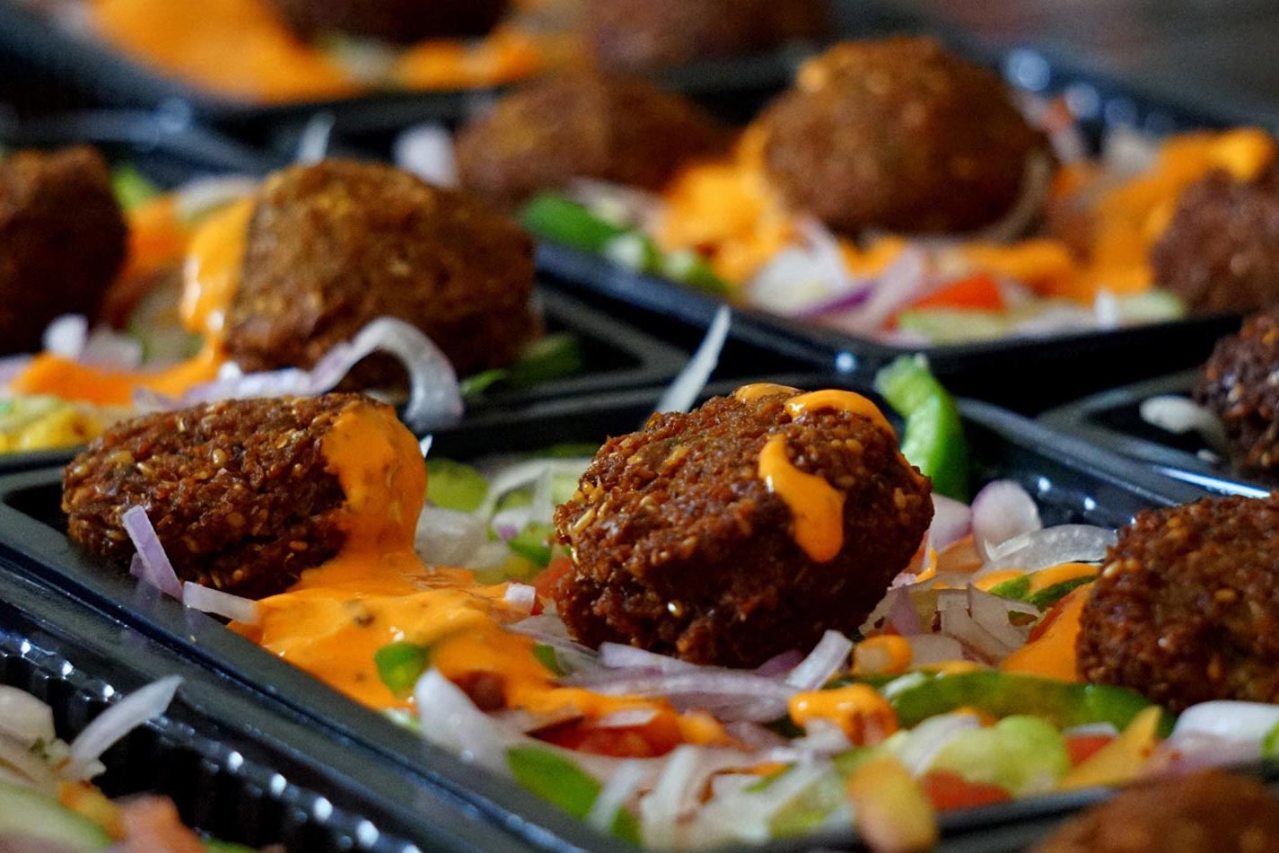 Up close view of a salad with falafel on them