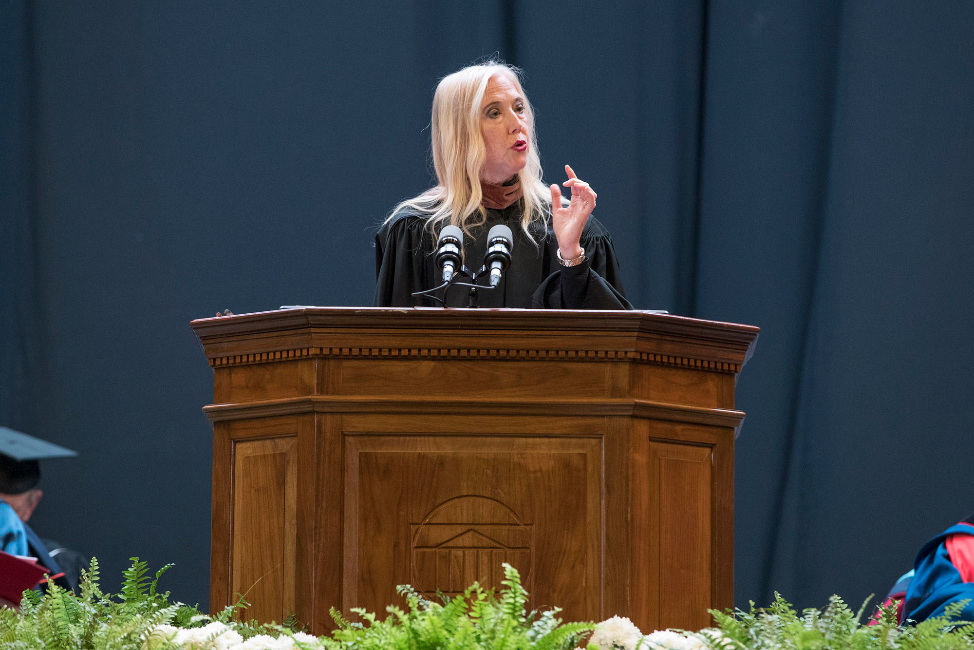 Poet Lisa Russ Spaar speaks at a podium at convocation