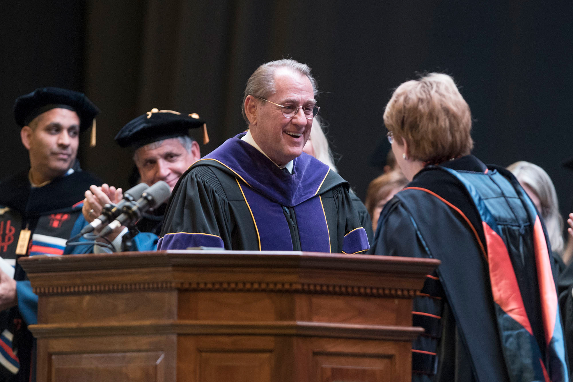 John Jeffries shakes hands with President Teresa A. Sullivan  on stage