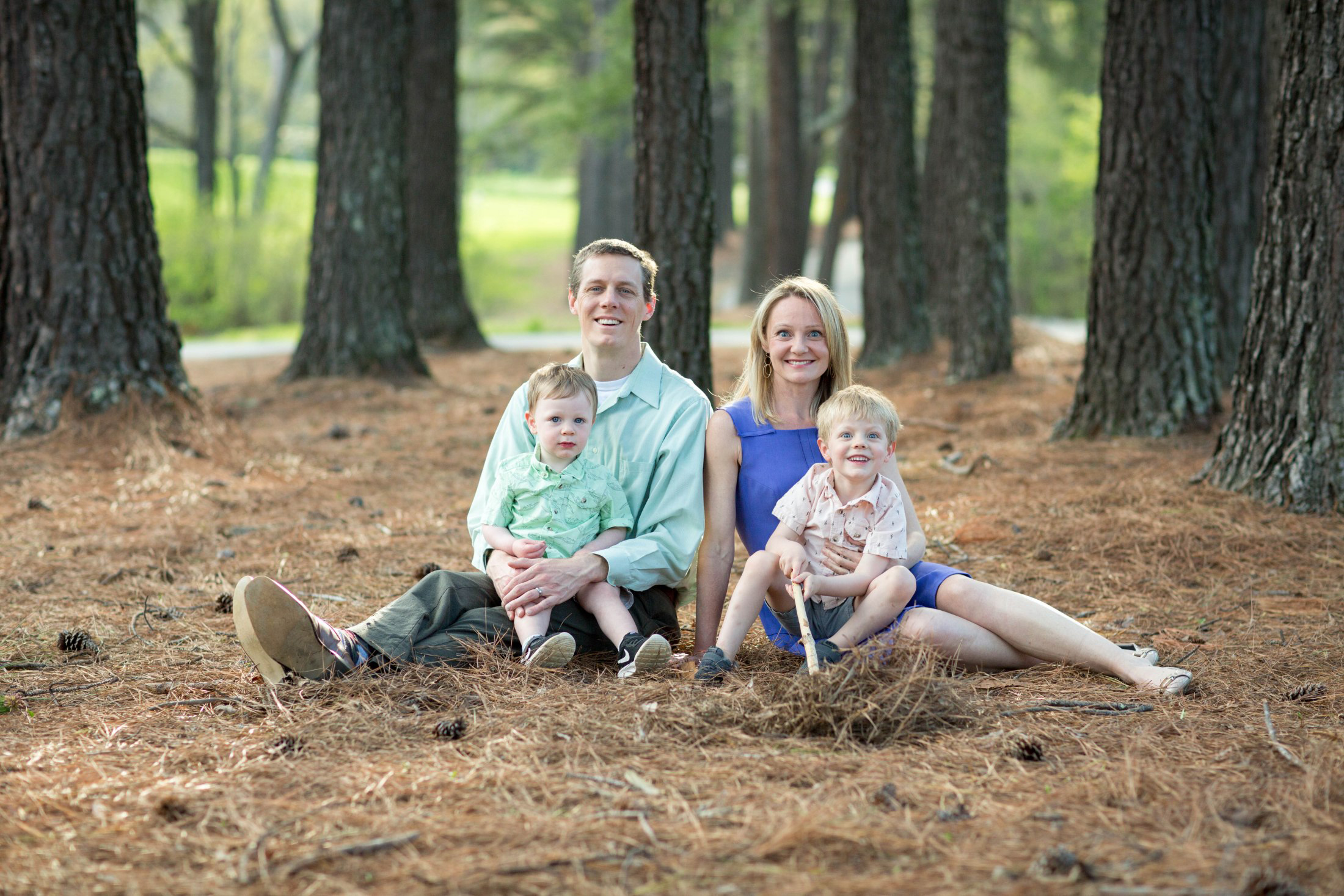 Dr. Kelleher and her family sit in pine needles