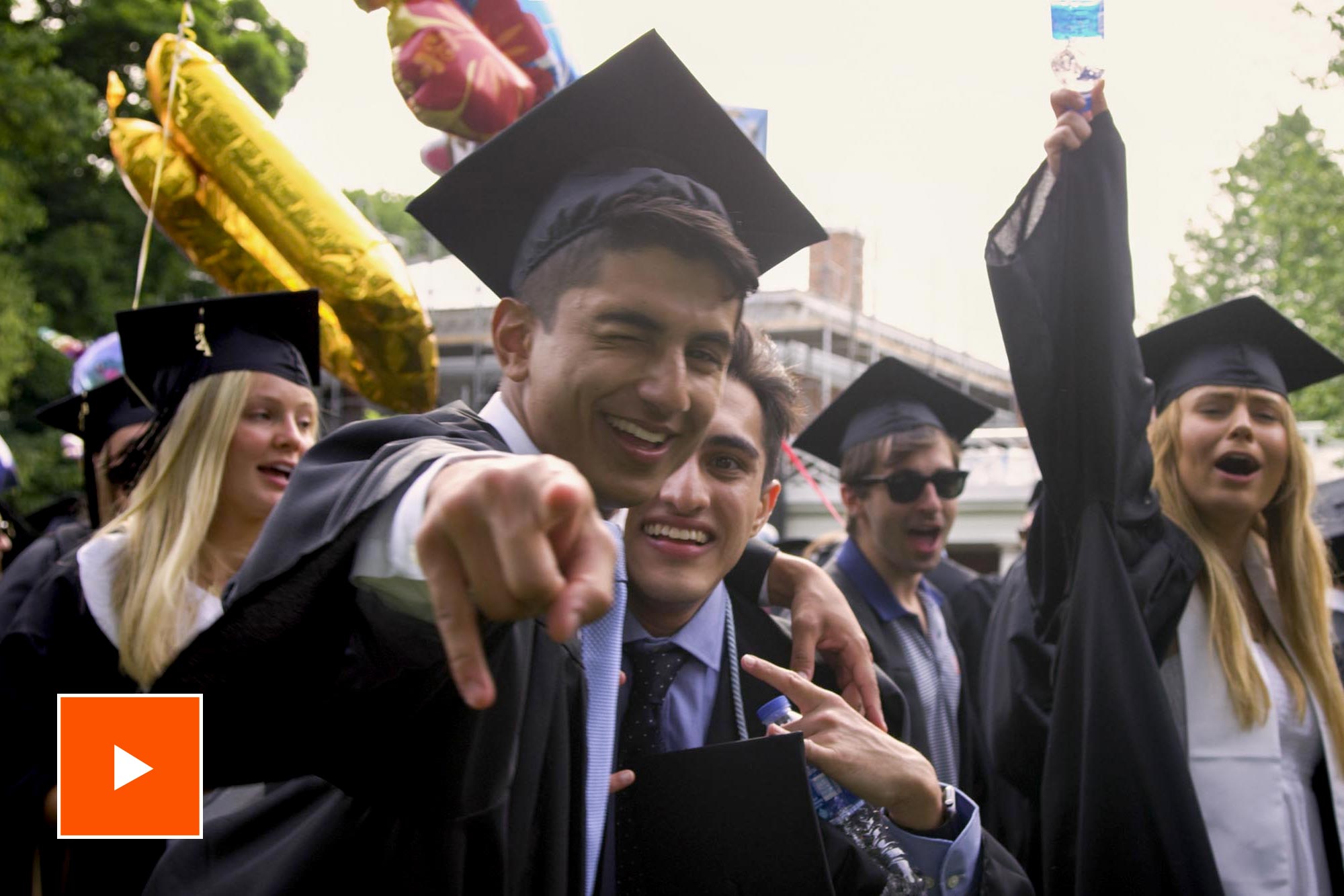 UVA Graduates celebrating with a play button to watch the video