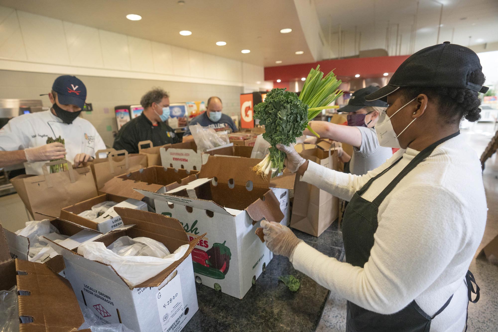 UVA Aramark employees packing brown bags with produce