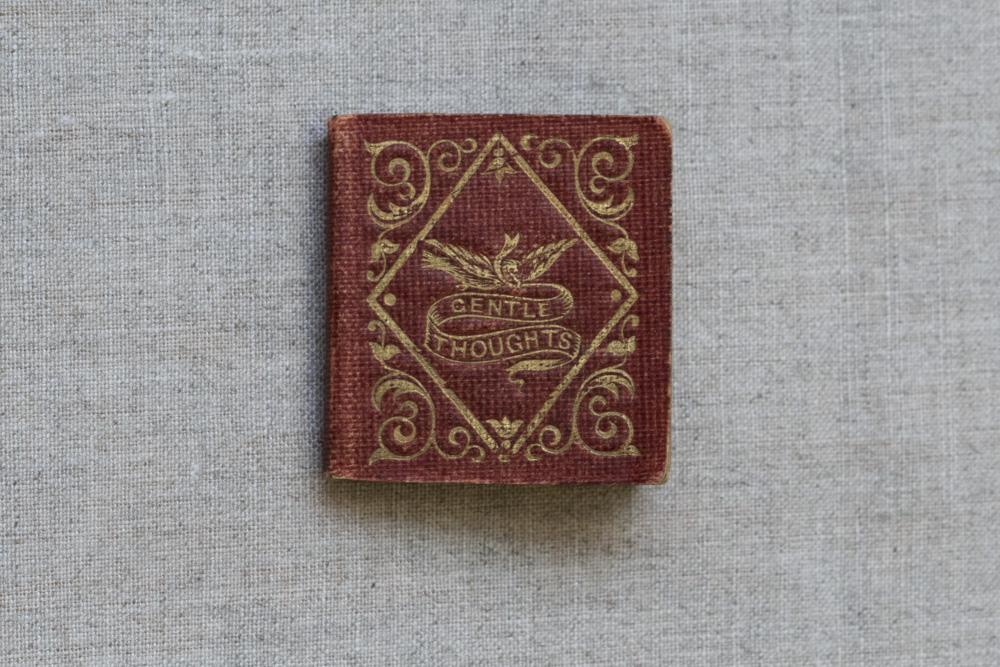 old fabric book cover that says Gentle Thoughts on a mini book