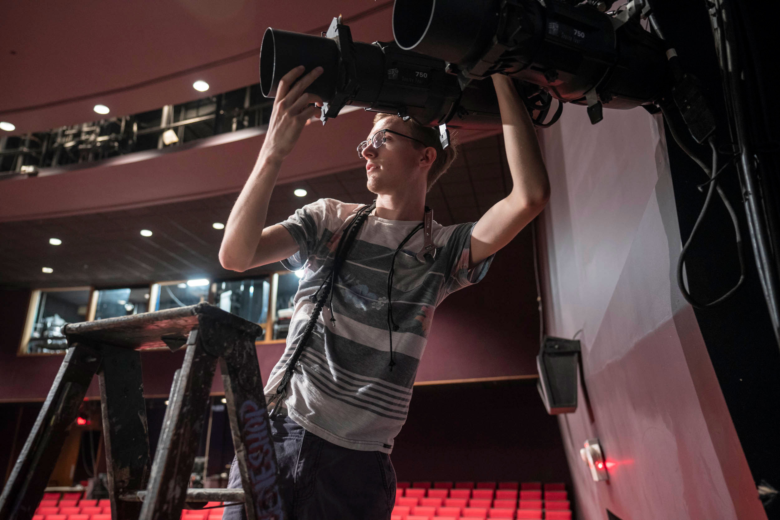 George Pernick adjusting lights on the theatre stage