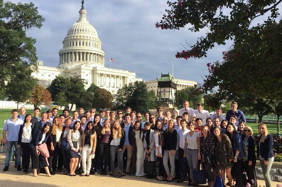 Students stand in front of the US Capitol building for a group photo