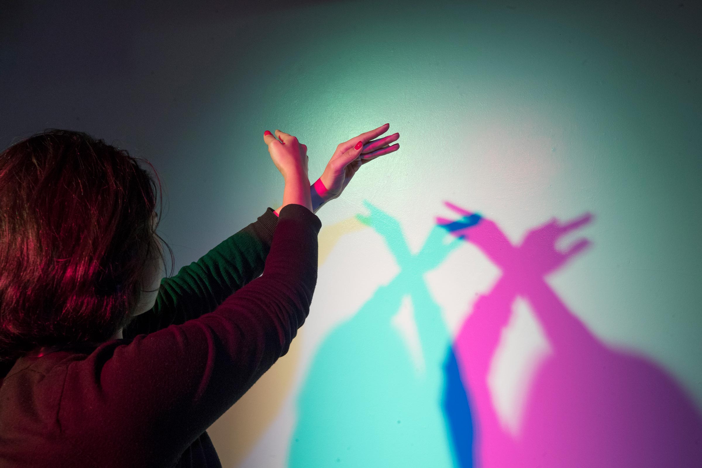 Student making shadow art with multi colored lights