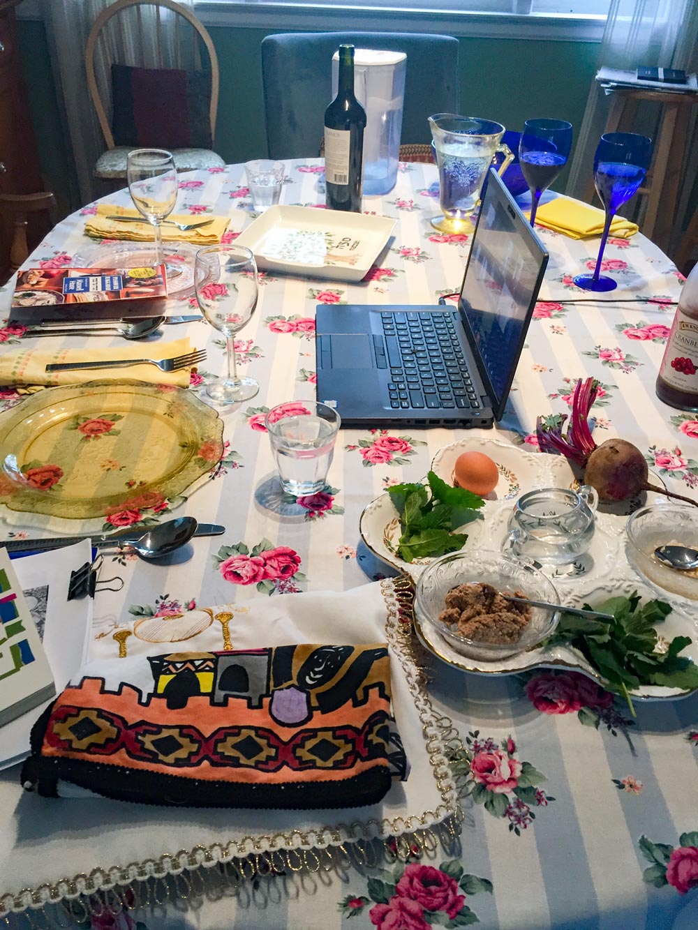 Laptop sitting on table with various food and dishes surrounding it