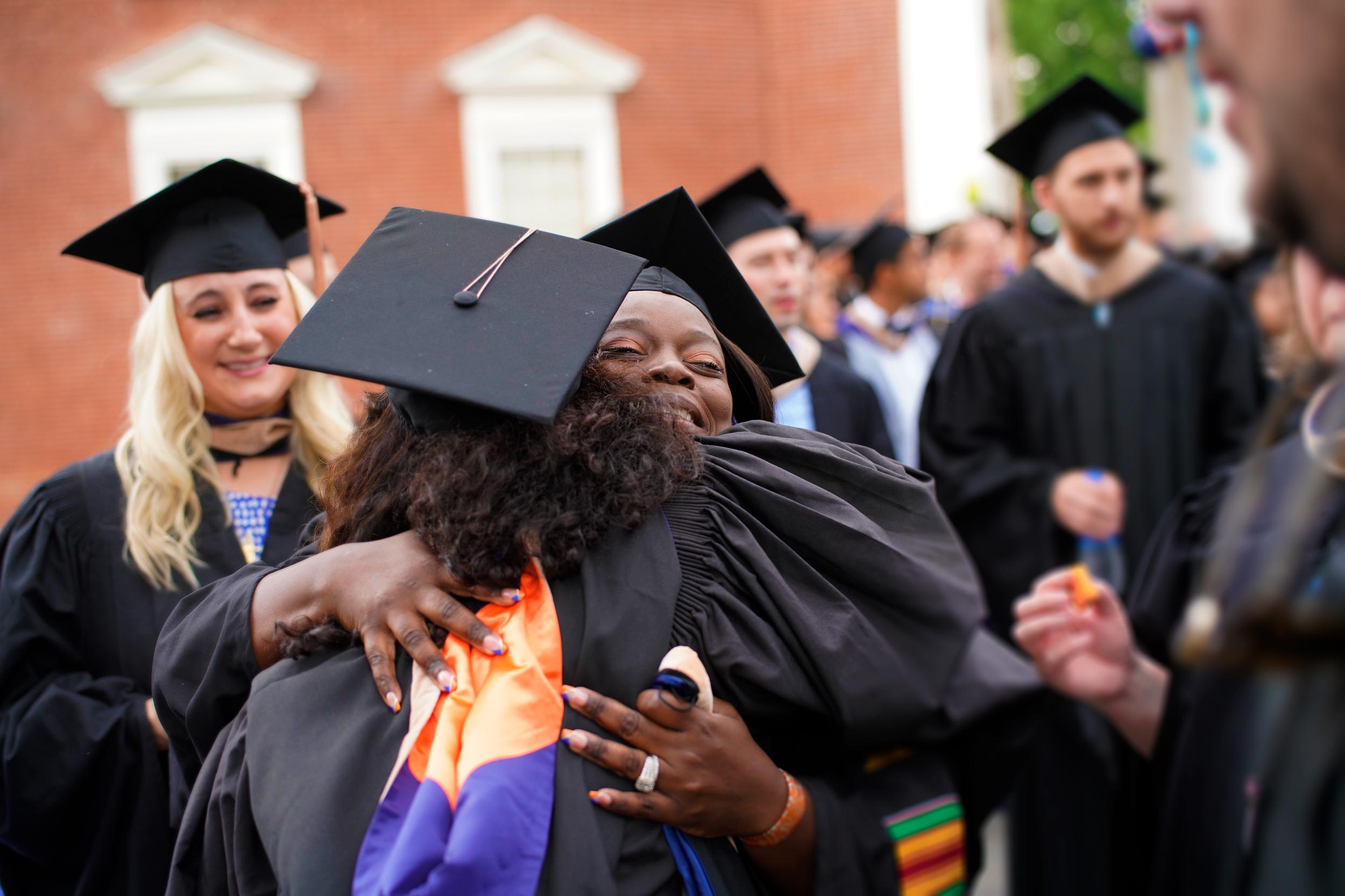 Two graduates hug