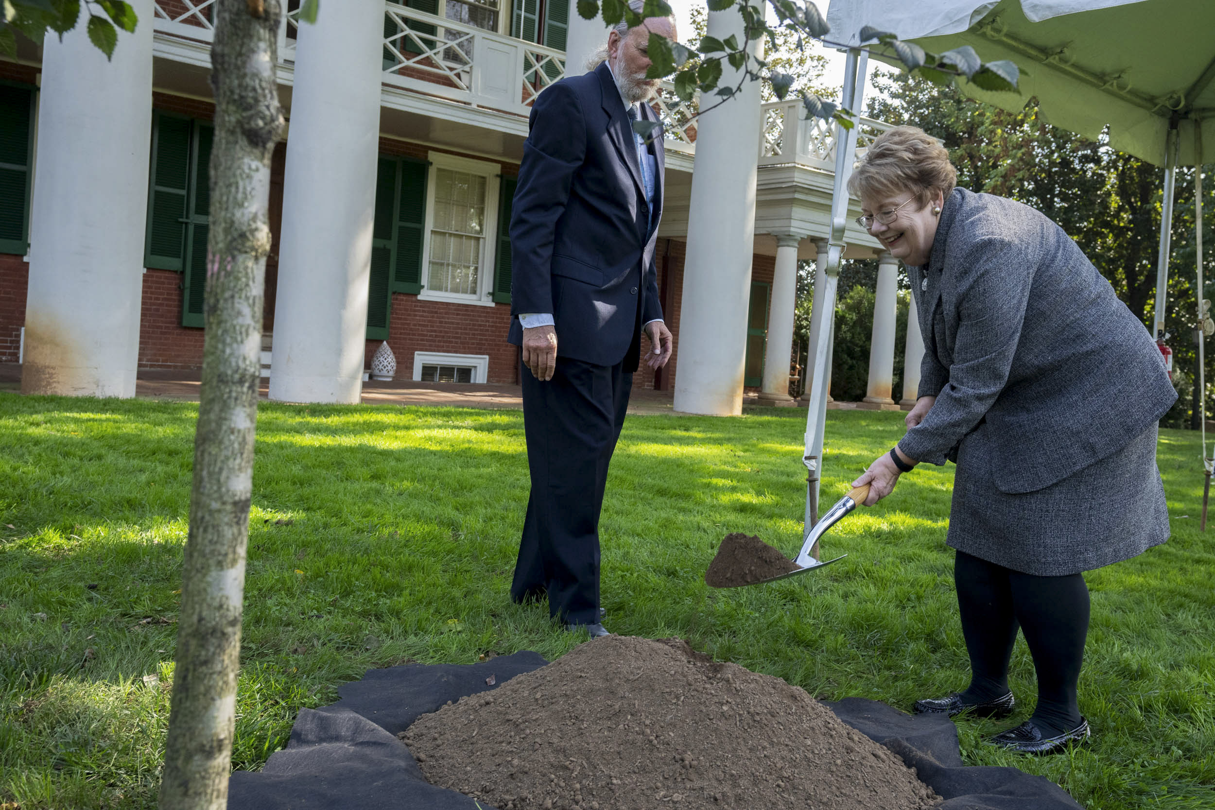 President Teresa Sullivan digging hole for the planting of her tree on the Lawn