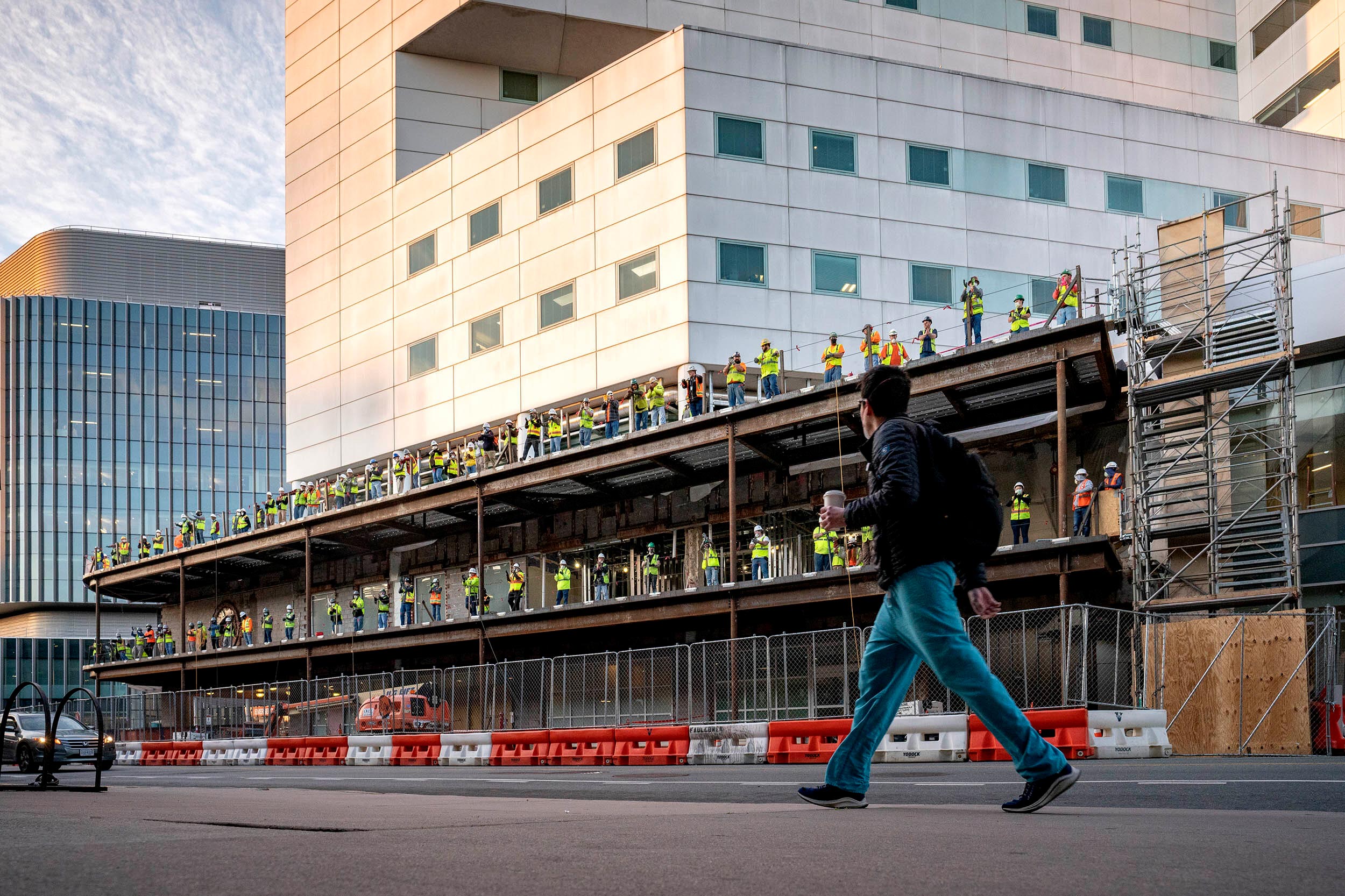 Construction workers stand to clap as healthcare works change shifts