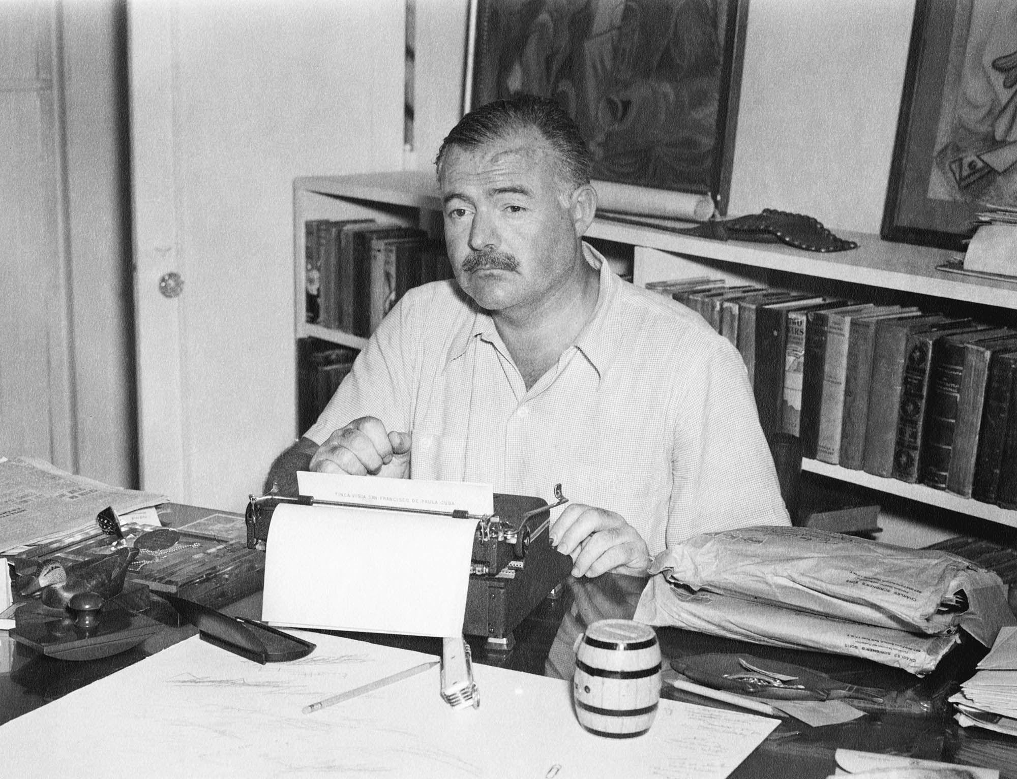 Hemingway sitting at a desk typing