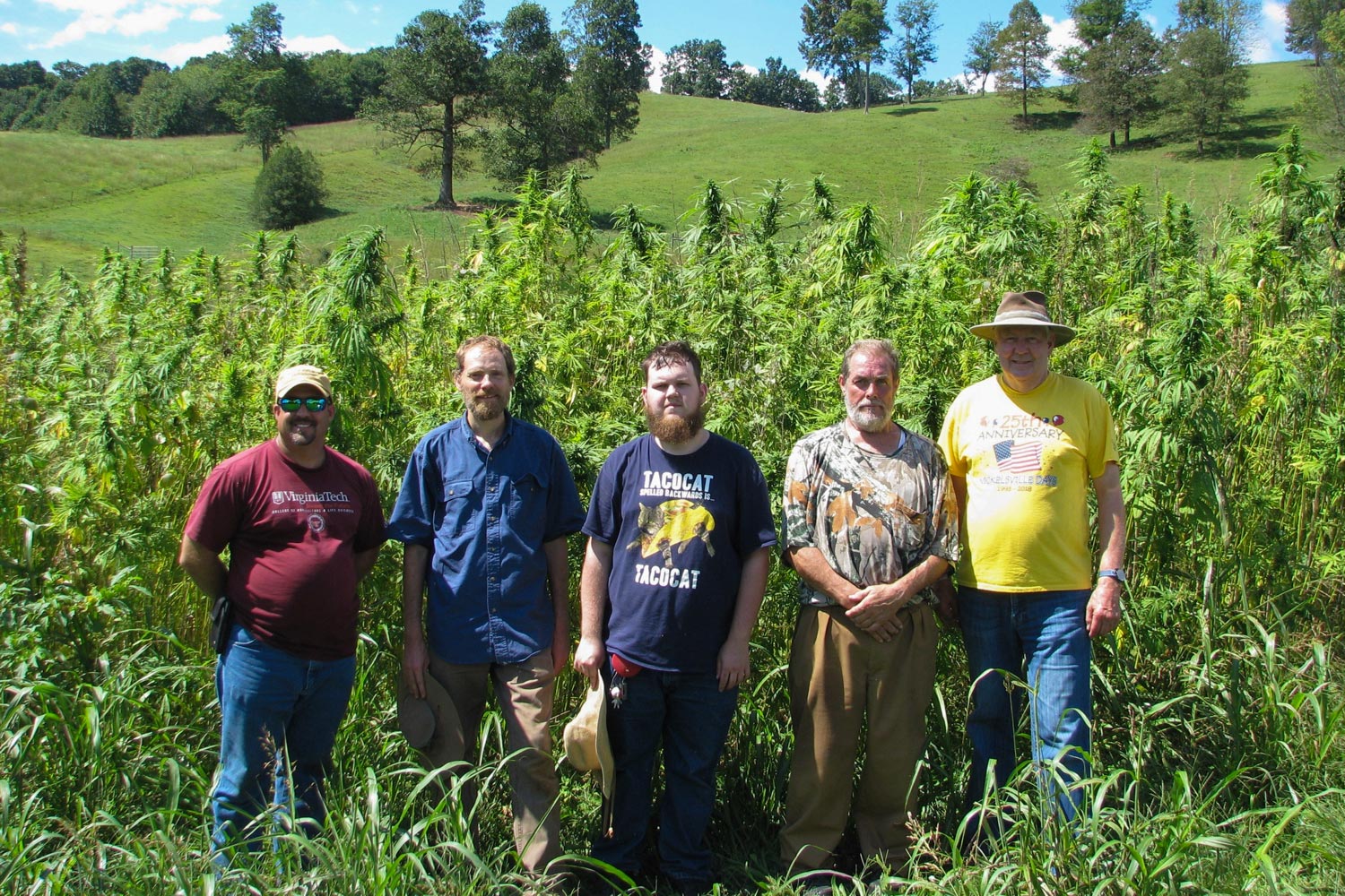 Huish, second from the left, poses with area farmers in front of a stand of hemp. 