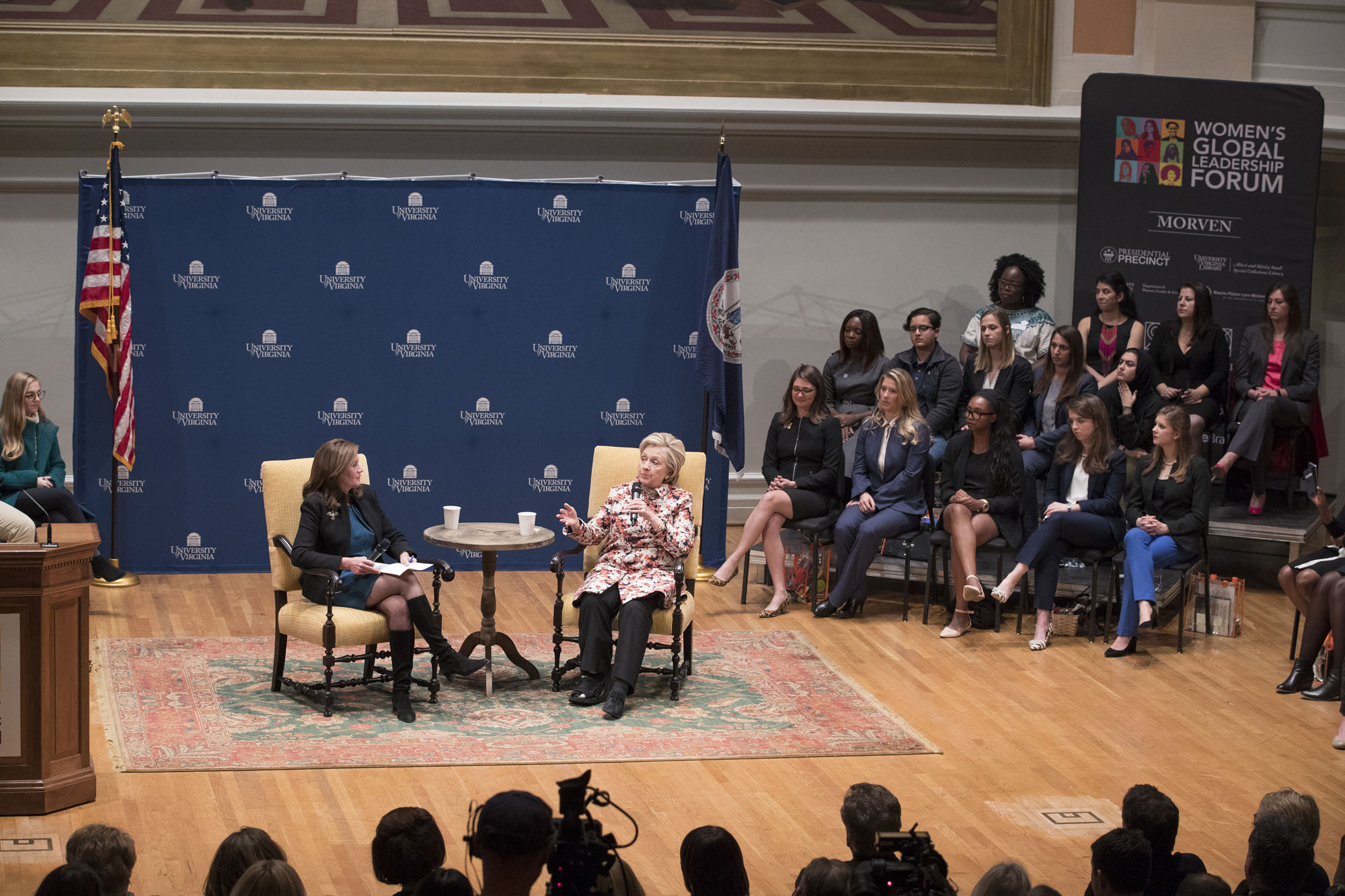 Dorothy McAuliffe and  Hillary Clinton sit in chairs as they talk to an audience