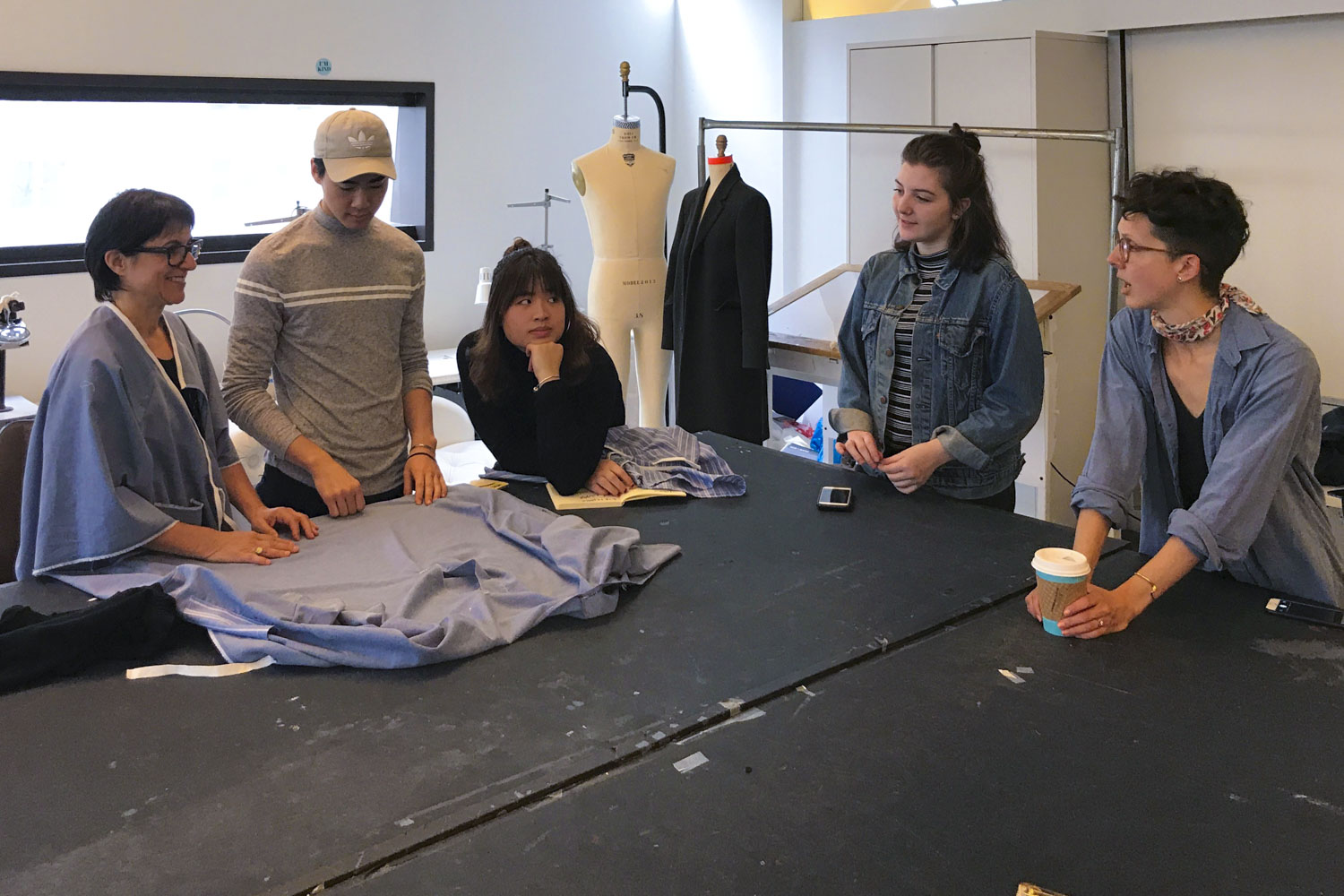 Care+Wear partnered with the Parsons School of Design to create the gowns. Here, teacher Brittany Dickinson, right, and her students talk with patient Joan DeCollibus, left, about a prototype gown. 