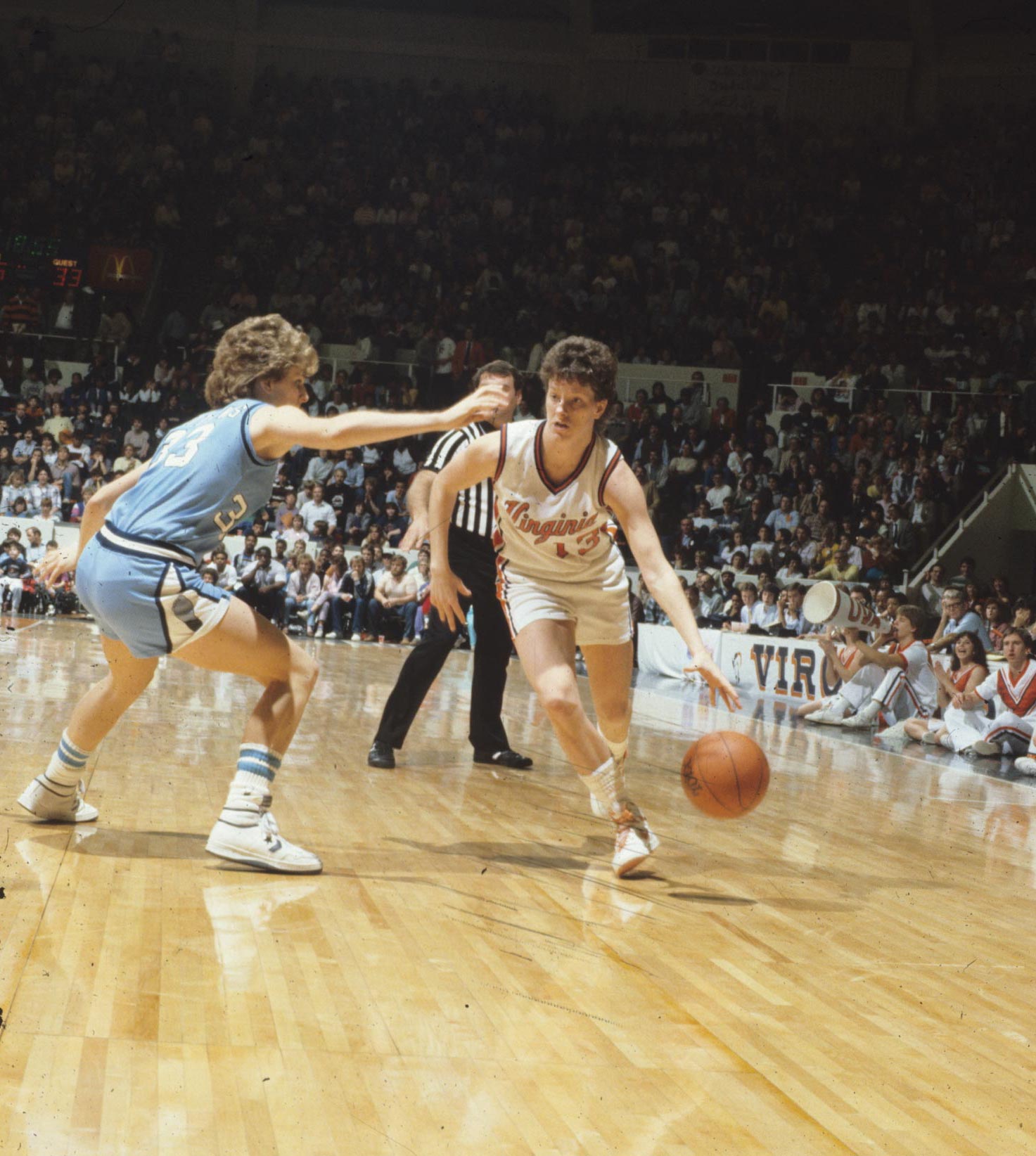 Old image of basketball player dribbling around an opponent