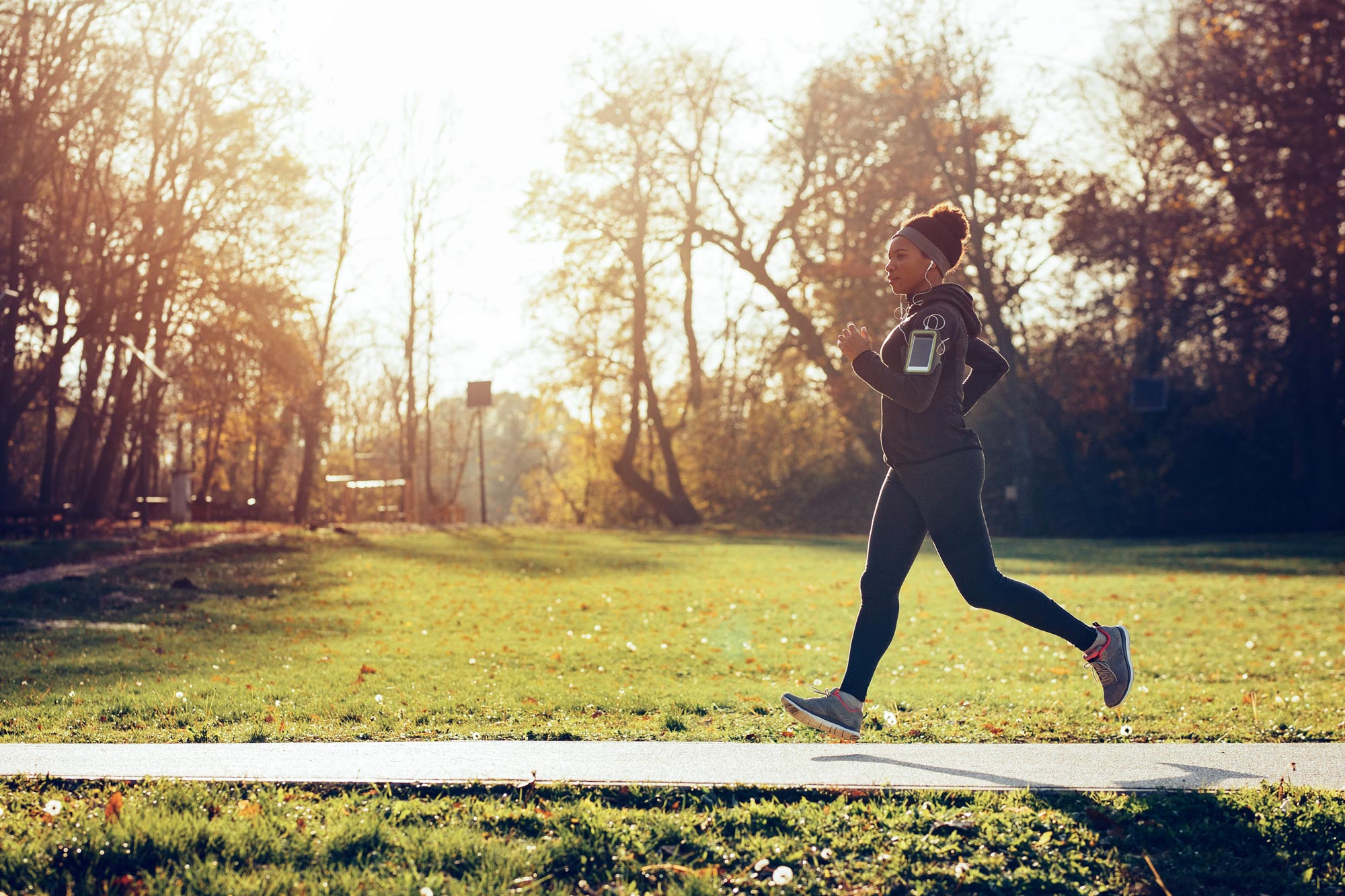 Woman Running on a side walk with the sun coming up