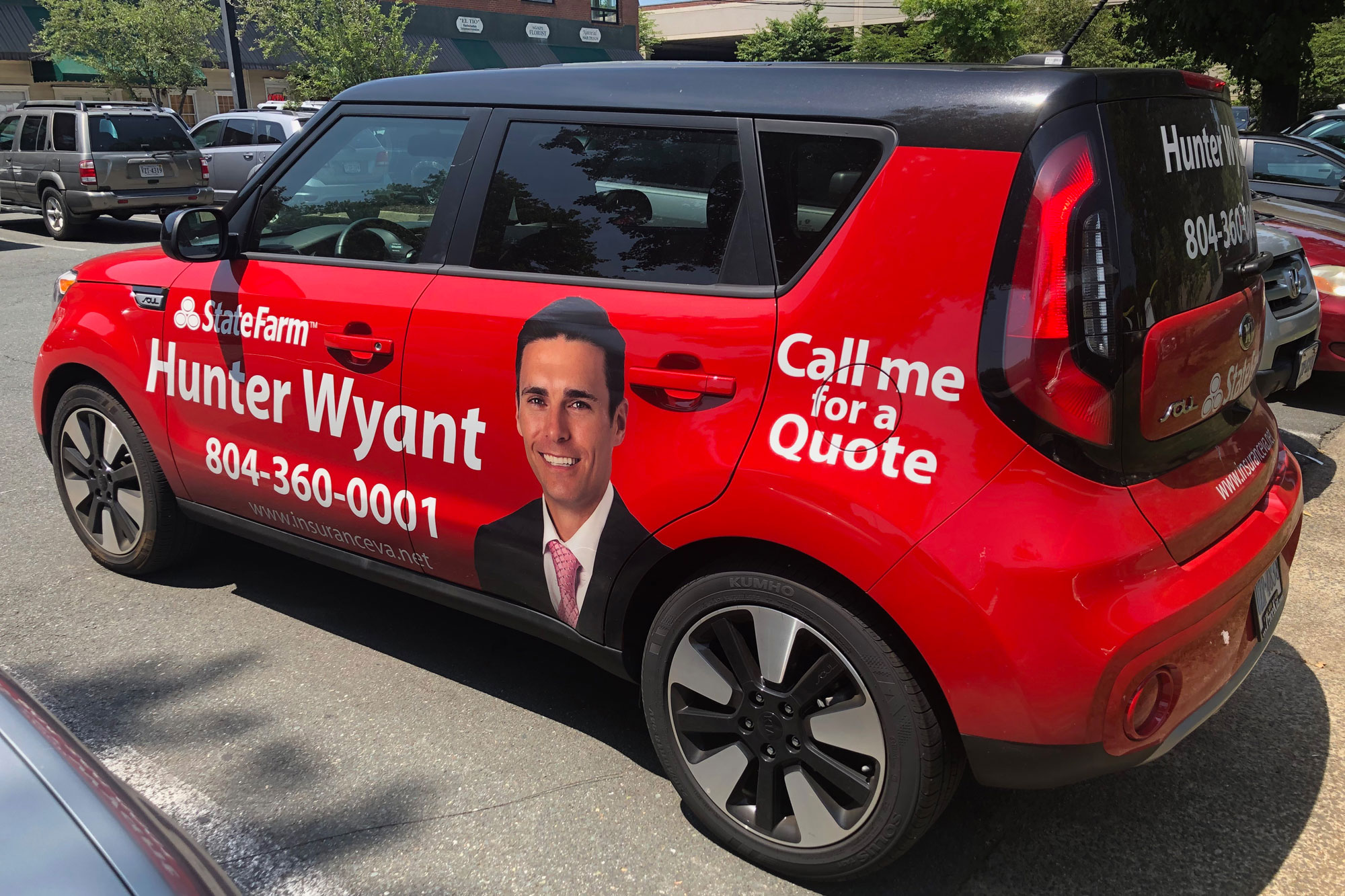 Red  and black State Farm Car with Hunter Wyants face on it and his contact information