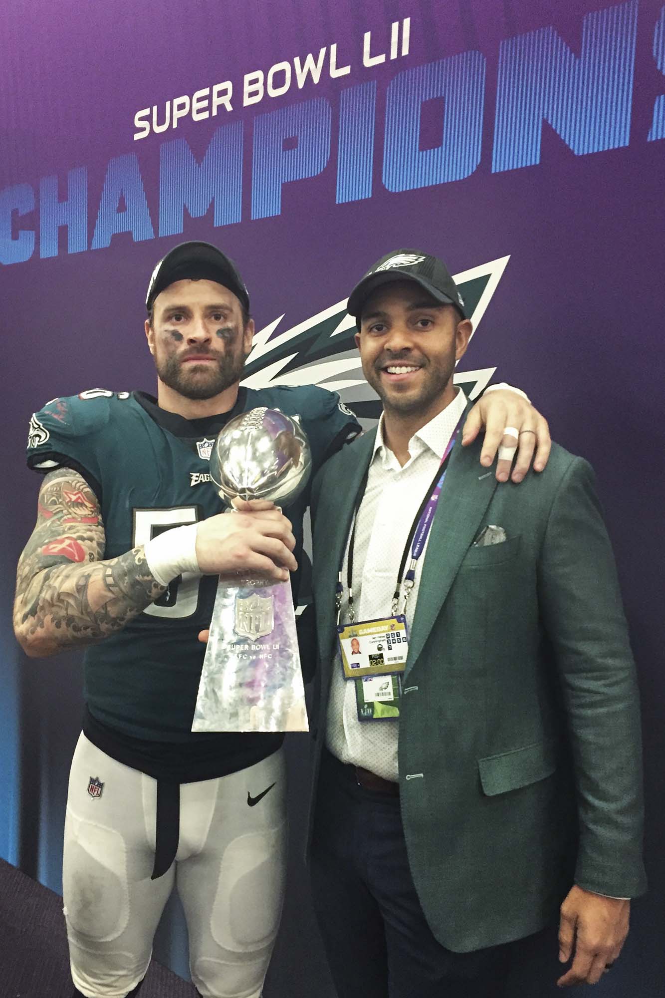 Cunningham, Long (left) standing next to each other holding the Super Bowl Trophy