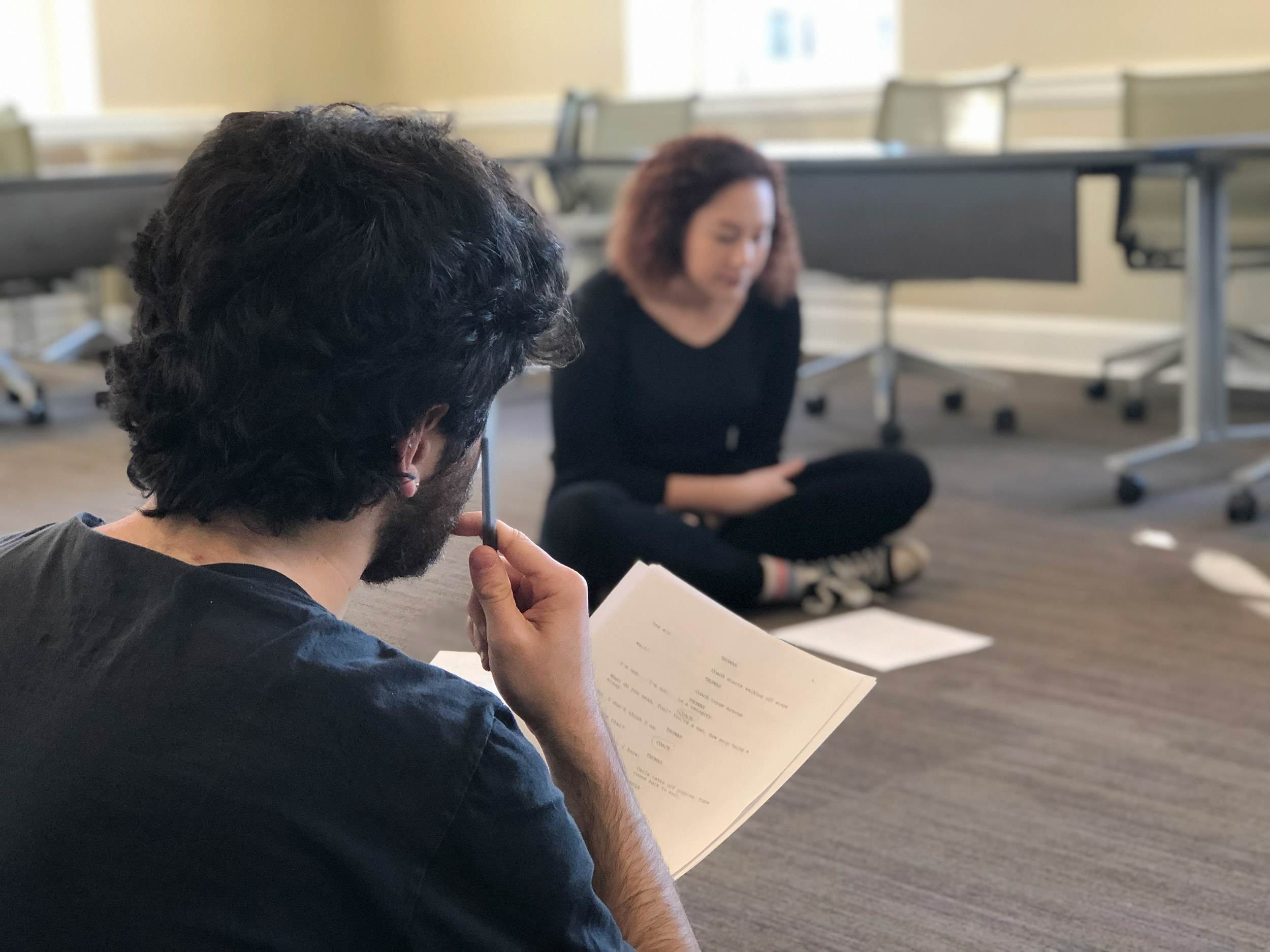 Nat Berelovich and Grace George rehearse their play while sitting on the floor