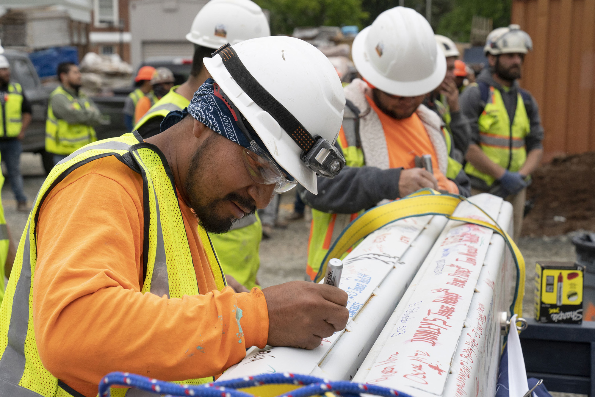 Construction workers signing the beam.