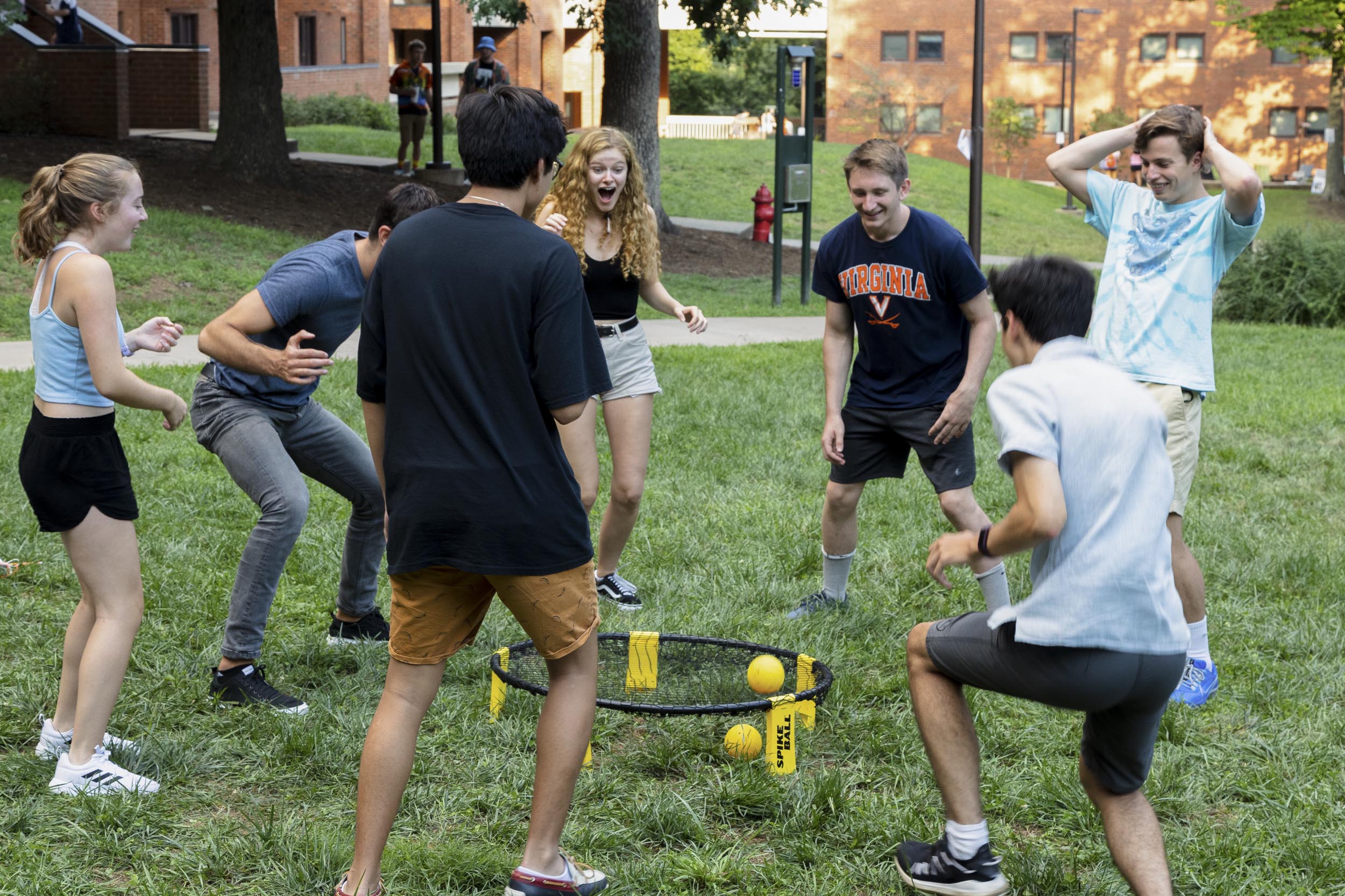 Group of students playing Spike ball outside in the grass together
