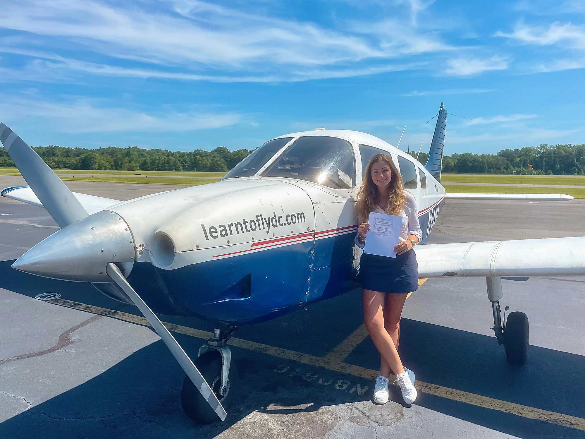 Gillian Moore standing next to her airplane on the Tarmac