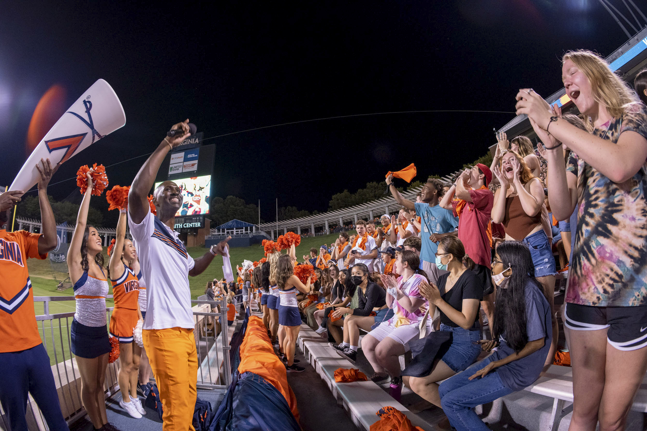 Crowd being led in a cheer by UVA cheerleaders in the stands