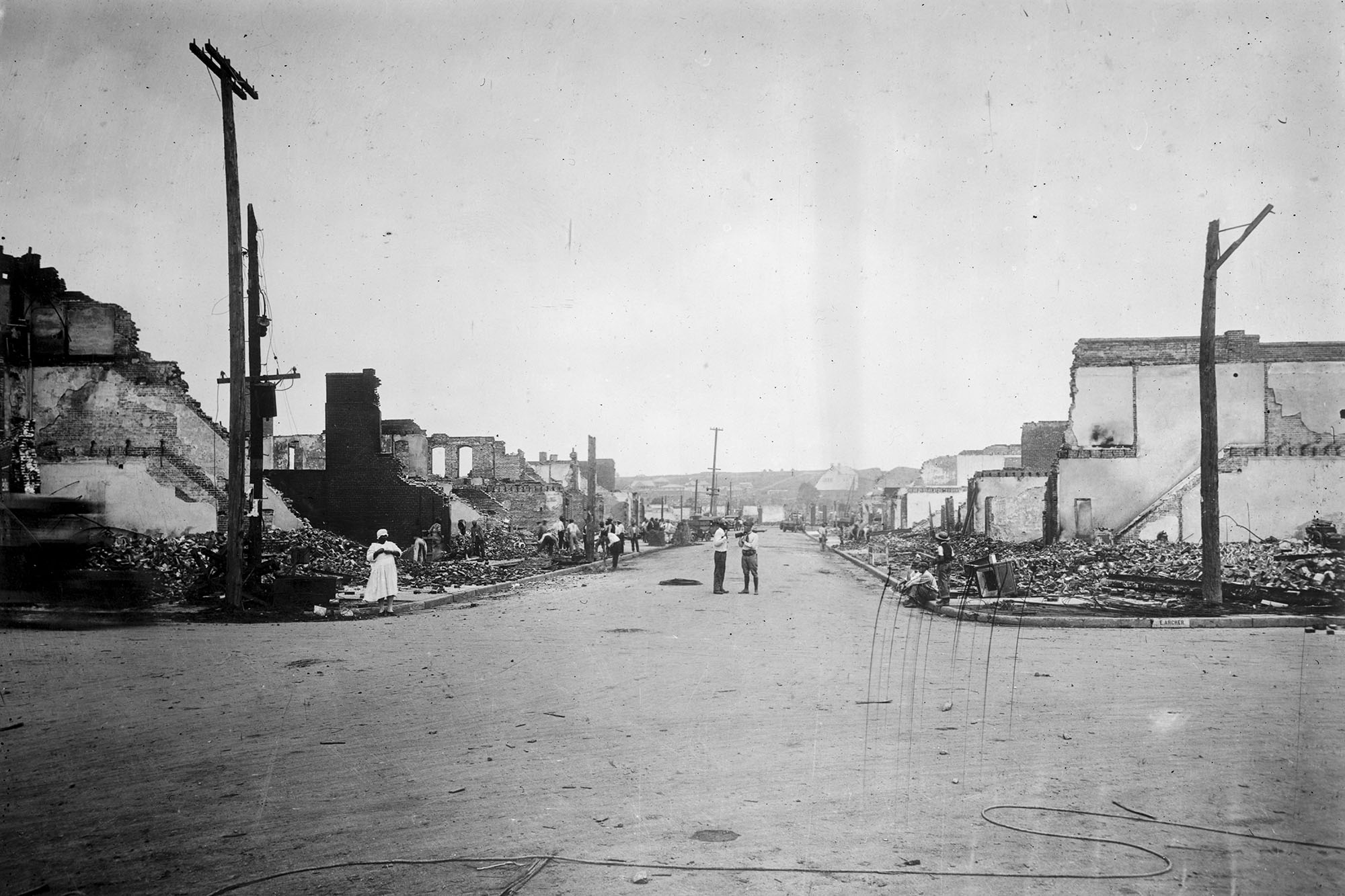 black and white photo of a street with buildings on both sides destroyed