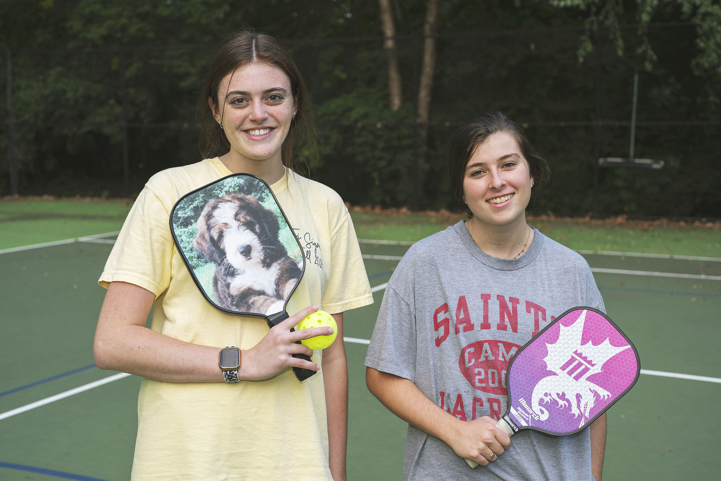 Delaney Stone, left, and Addie Wood, right, holding their pickleball paddles as they pose for a picture