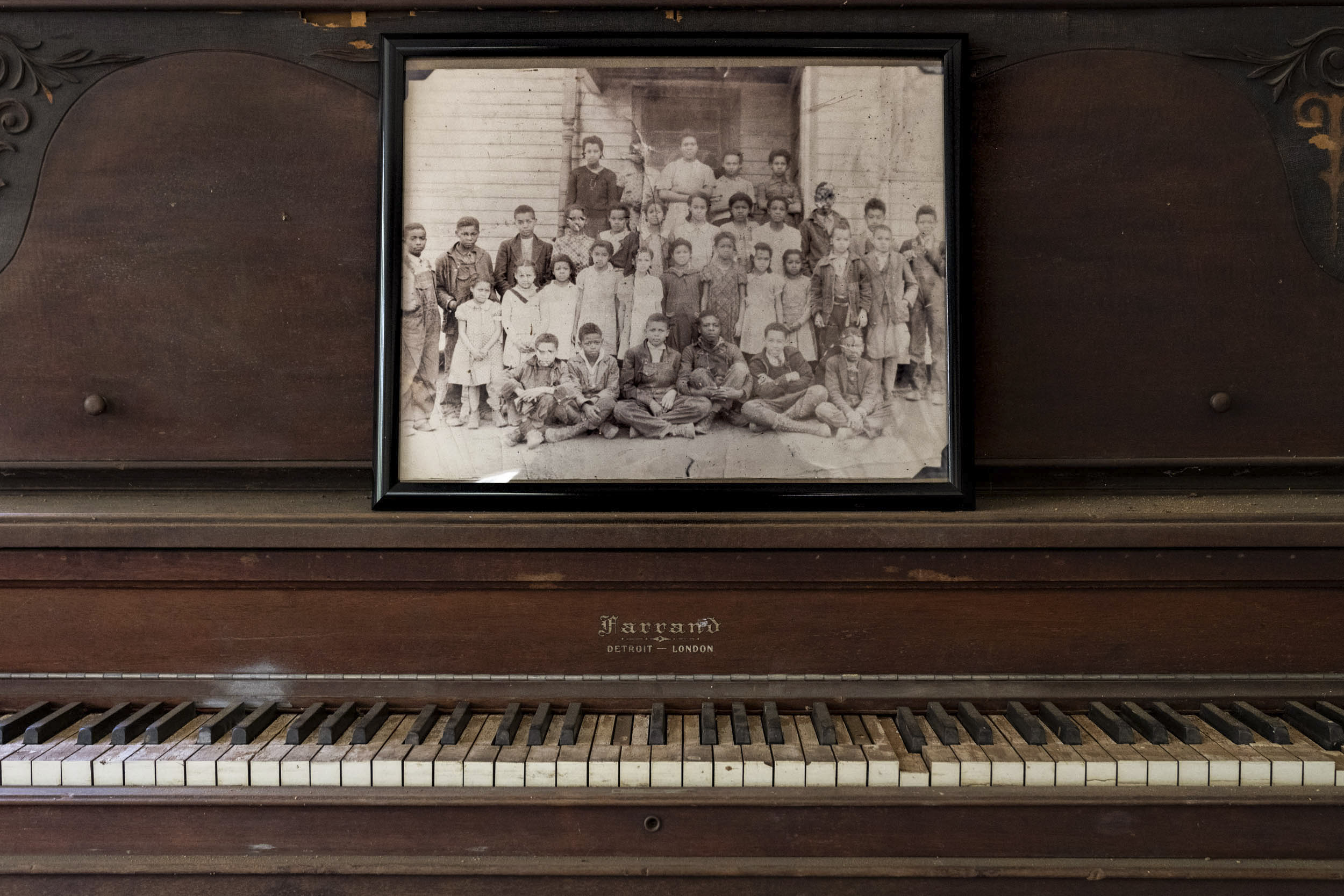Old piano with a black and white photo of children who attended the Pine Grove School