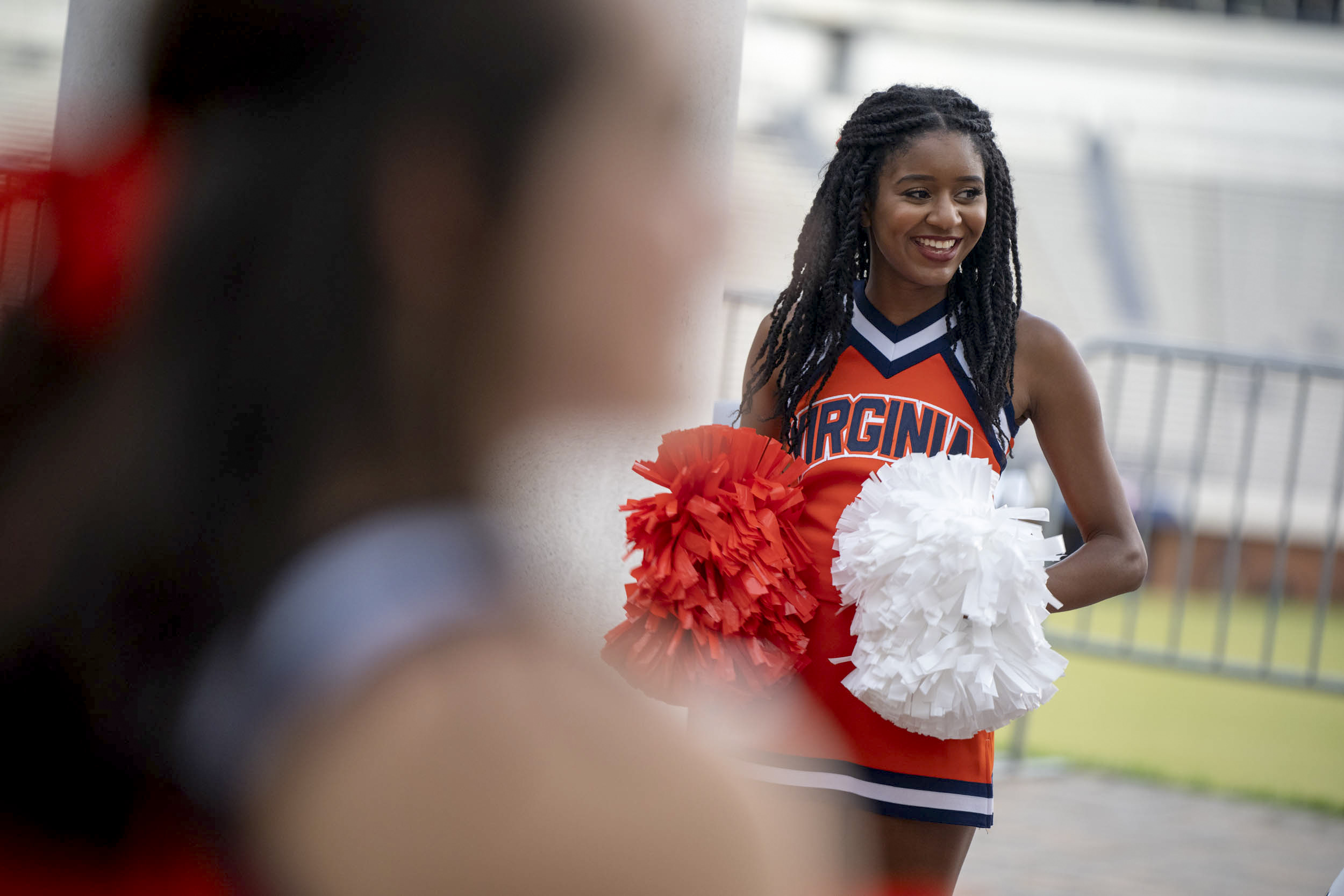 UVA Cheerleader holding orange and white pom poms