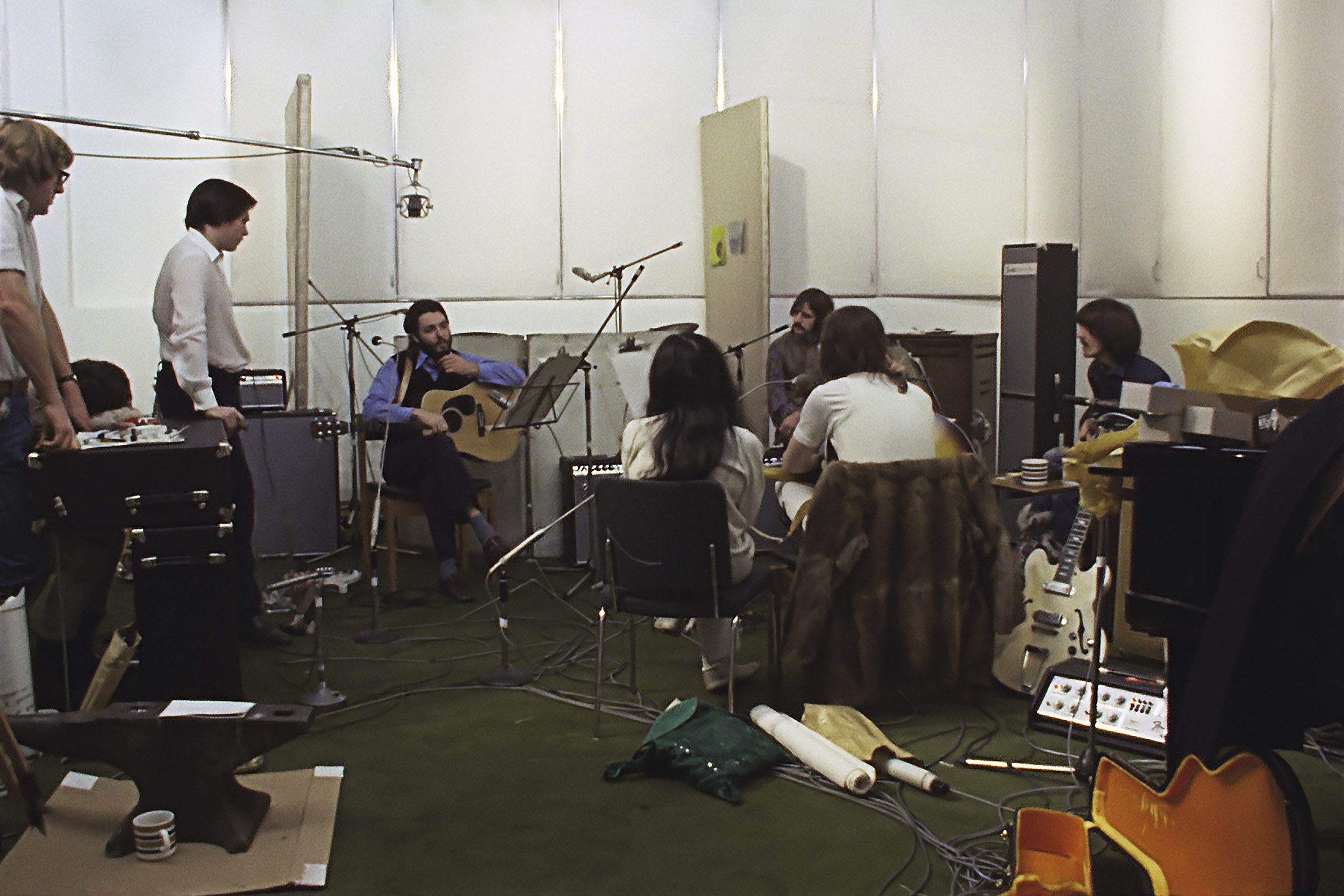 Group of musicians sitting around talking in recording room