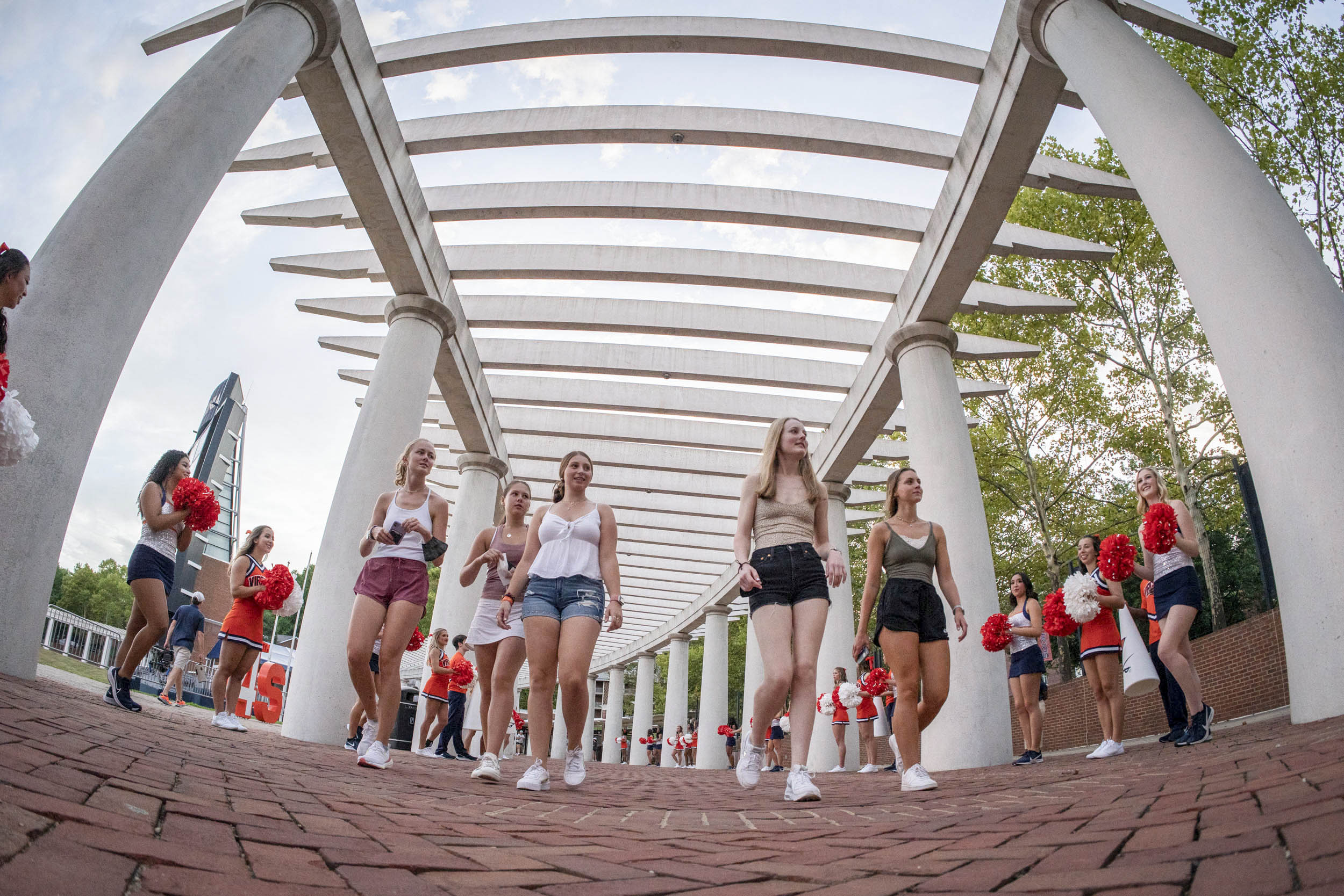 Students walking around the amphitheater with UVA cheerleaders lining the walkway 