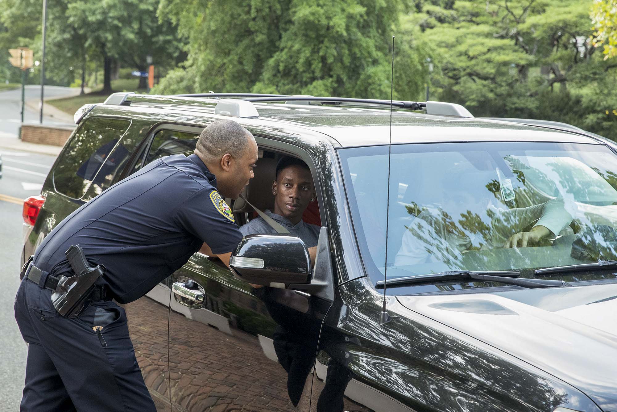 Capt. Bryant Hall speaking to passengers in a black SUV 