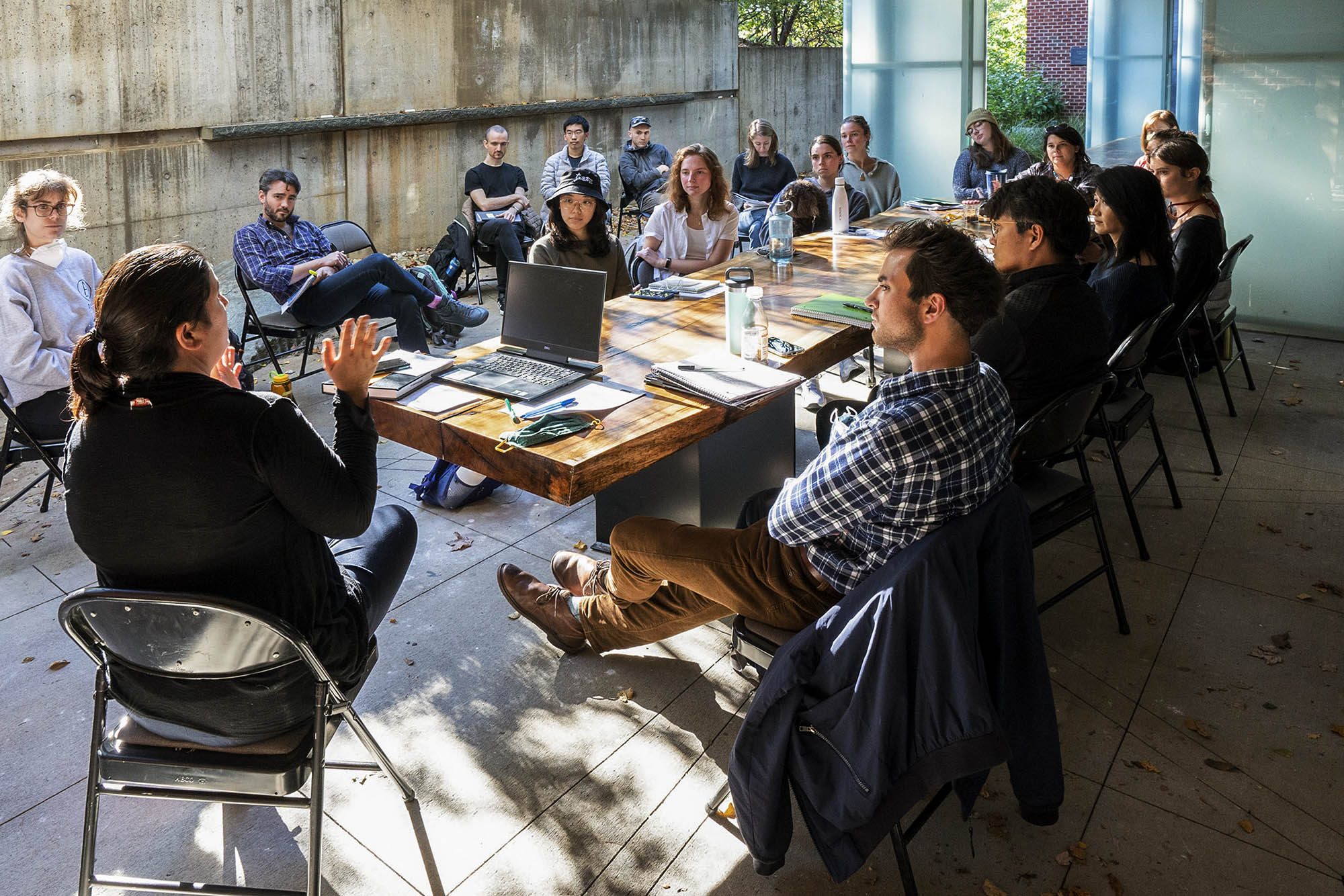 group of students listening to school of Architecture professor speaking at an outdoor table