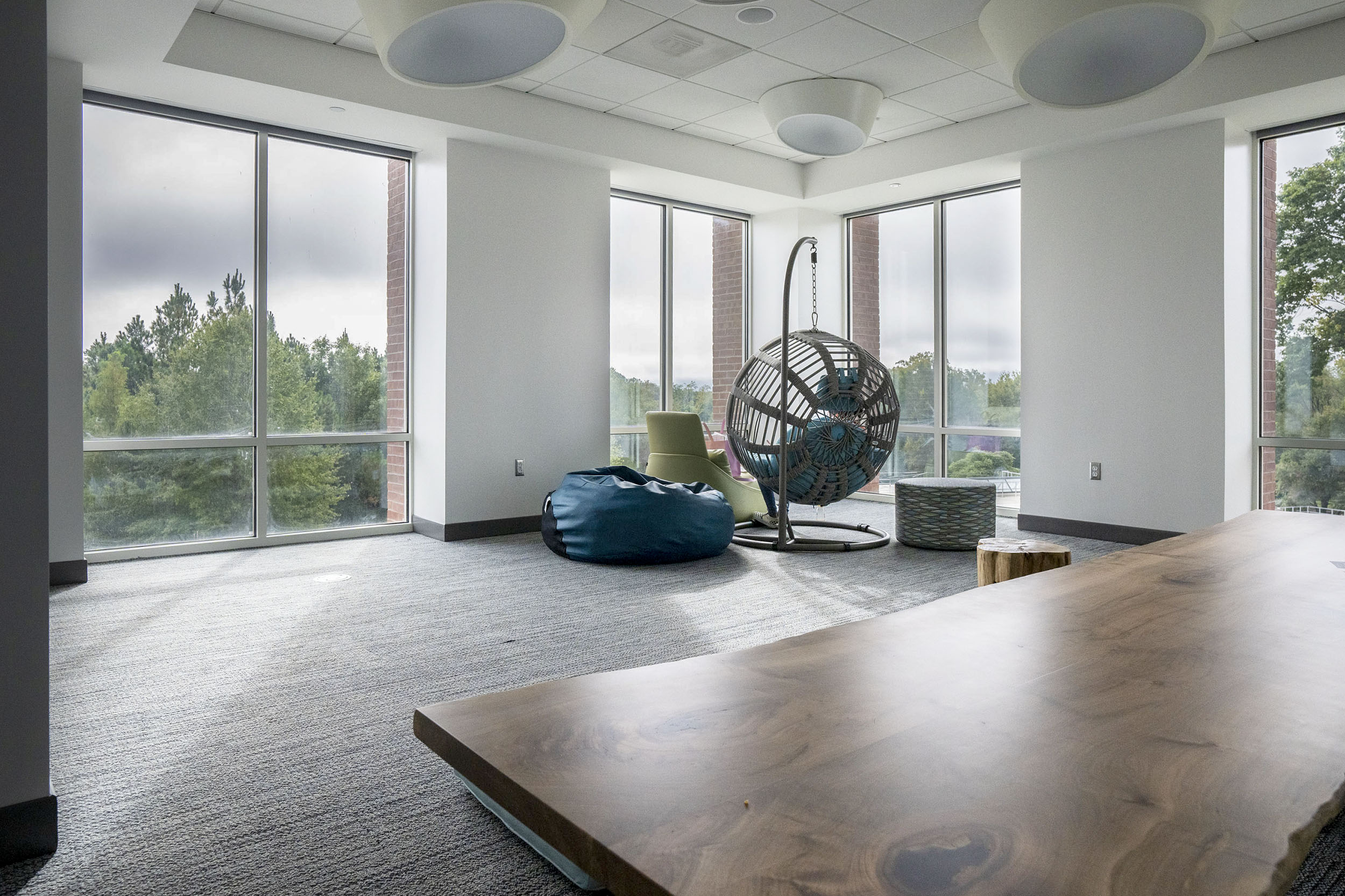 Room in the Student Health and Wellness center with a table, bean bag chair, hammock chair, and yoga mats
