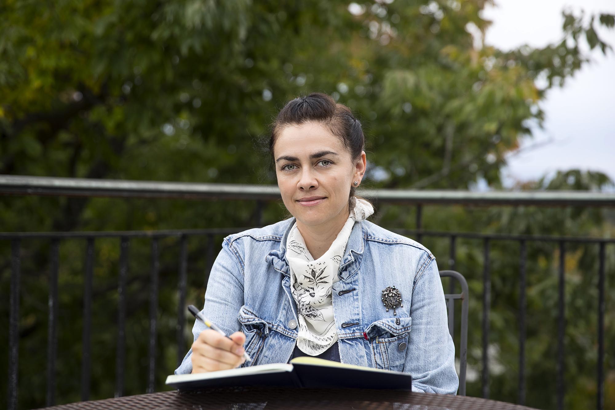 Sally Pusede sitting in a chair with a pen and notebook