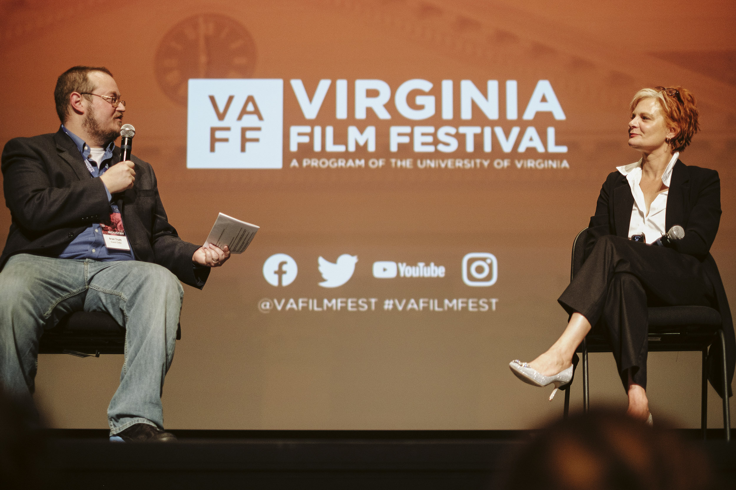 Man, left, speaking to a woman, right, on stage during the VA film festival