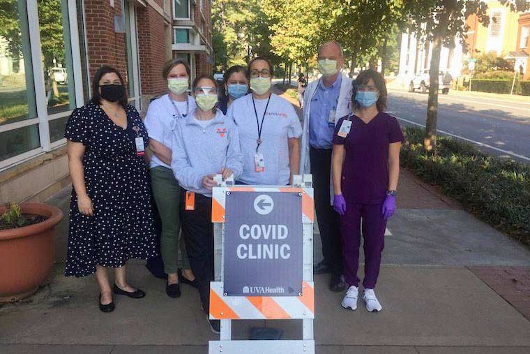 Bridgette Arlook, Christy Breeden, Rebecca Wade, Crystal Reed, Jennifer Pinnata, Dr. William A. Petri Jr. and Andrea Stanley pose for a photo outside of a covid-19 clinic