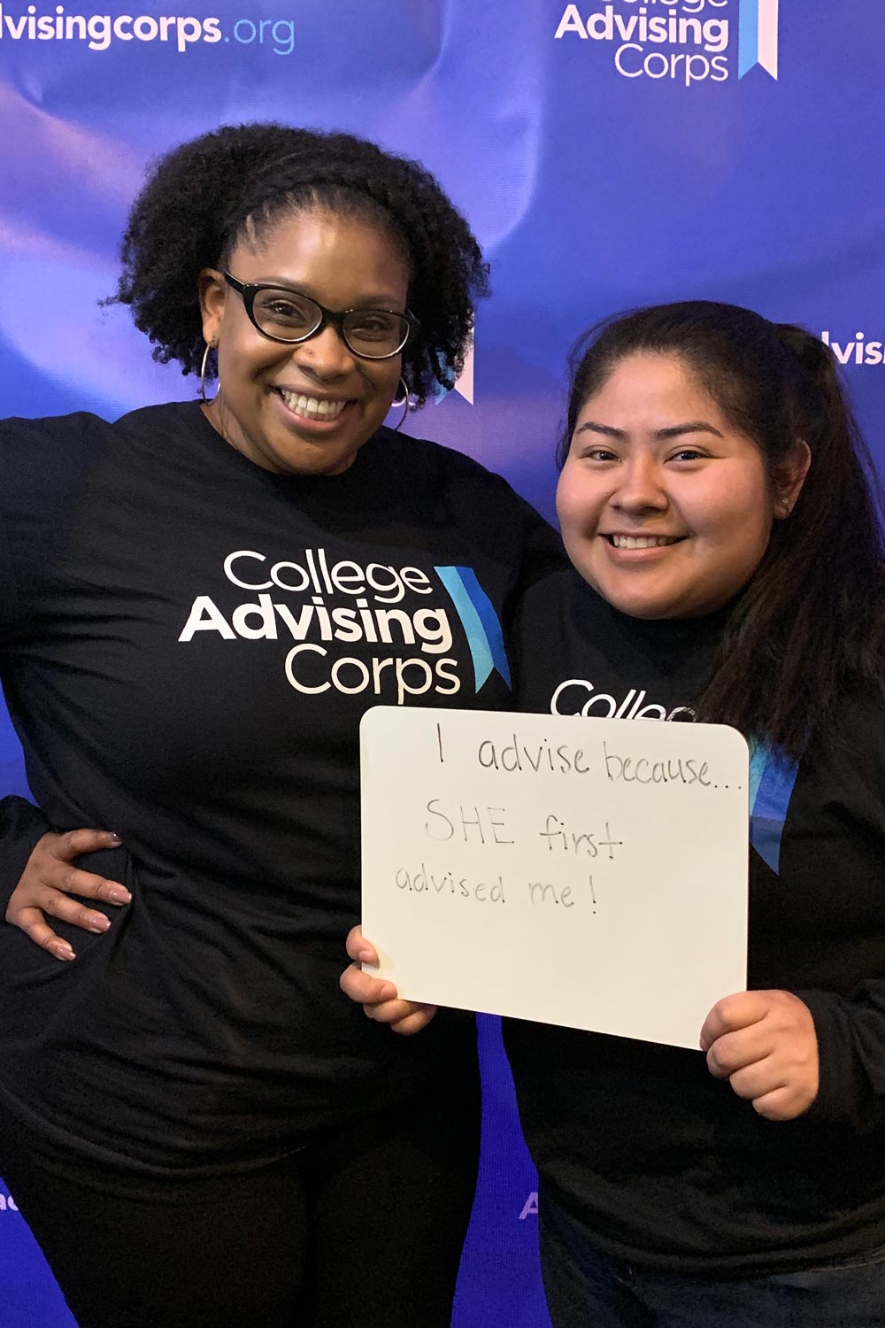 Alex Johnston, left, Melinda Espinoza, right hold a sign that reads I advise because...she first advised me!