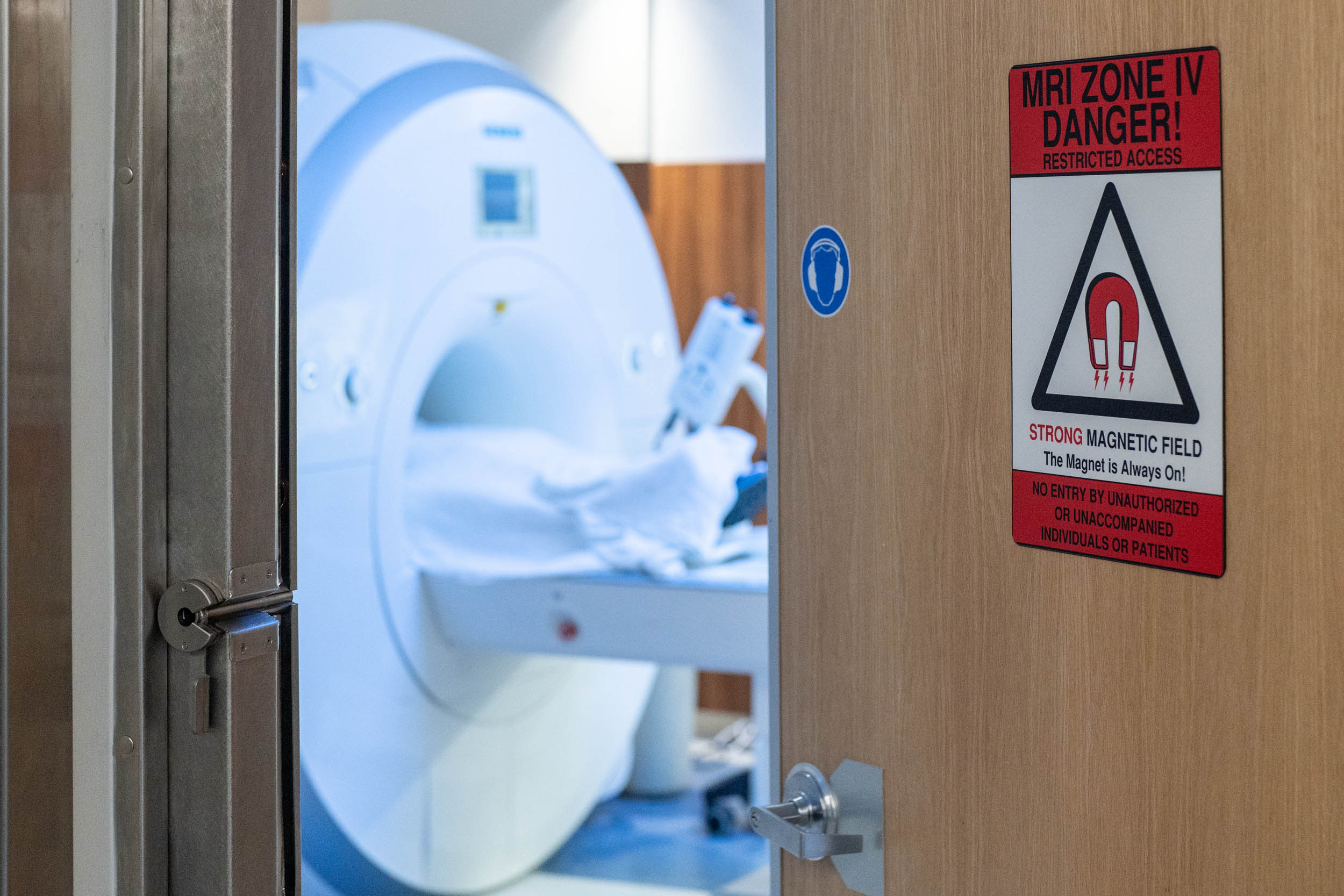 Door to a MRI open so that we can see the machine.  Door reads MRI Zone Danger!