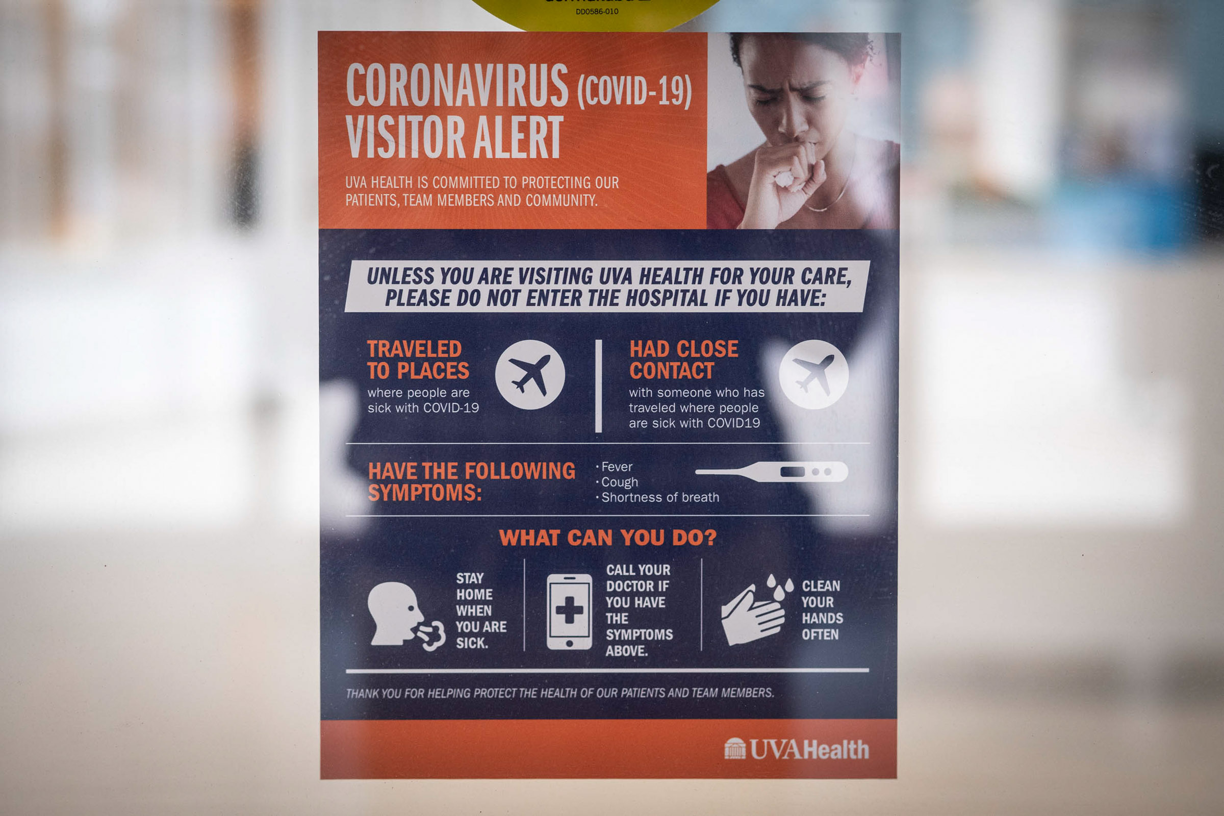 Coronavirus Visitor Alert poster taped to a glass wall