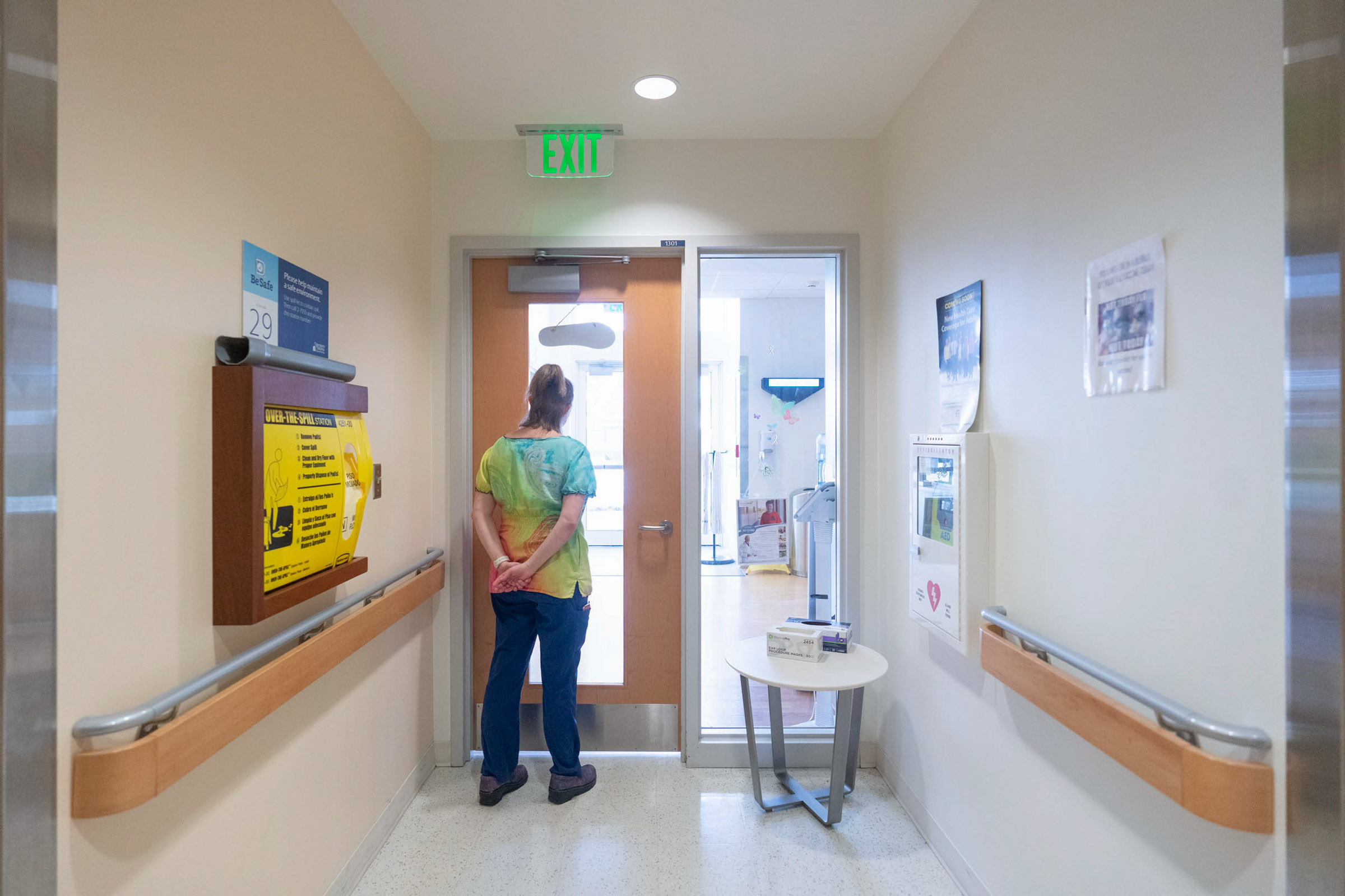 UVA Health Staff Member standing at a door looking through thee glass